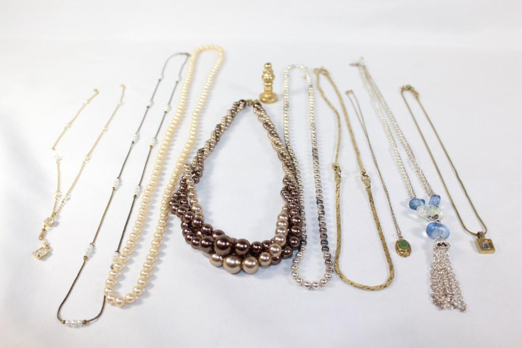 Lot of 9 Costume Jewelry Necklaces: Gold and Silver colored necklaces, including faux pearls, blue, green, and white rhinestones. as pictured
