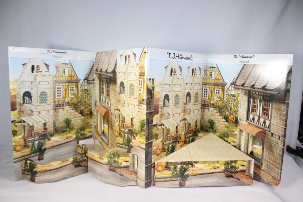 MJ Hummel Goebel Cardboard display: Cardboard Bavarian Village Display. Dated 1989 West Germany. Measures about 15 3/4" tall and 31" wide. Damage? - Base does not seem to connect on right side - shown in photos.