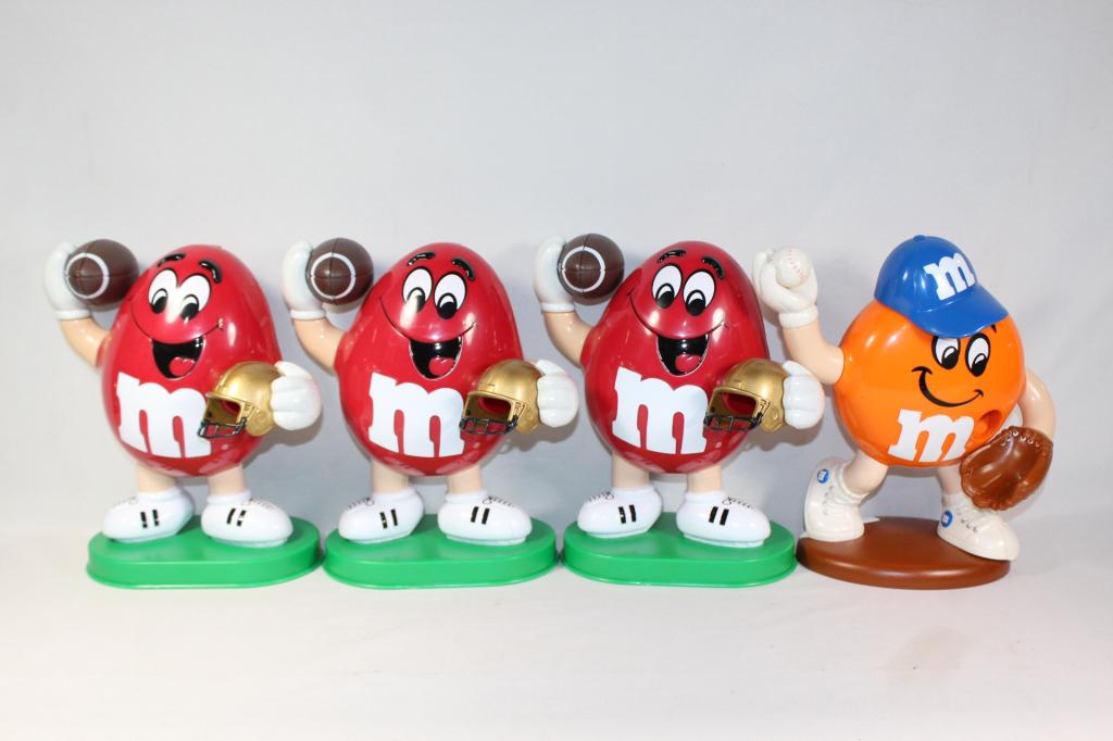 Lot of 4 M&M Sports Candy Dispeners: Inclues 3 Red M&Ms throwing Footballs and 1 orange M&M throwing a baseball; about 11 inches tall