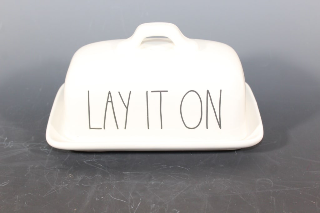 Rae Dunn Artisan Collection Butter Dish/cover: Butter dish top has the words 'lay it on' and the butter plate has 'thick.' Total length is approx. 8 inches long and 4 1/2 inches wide.