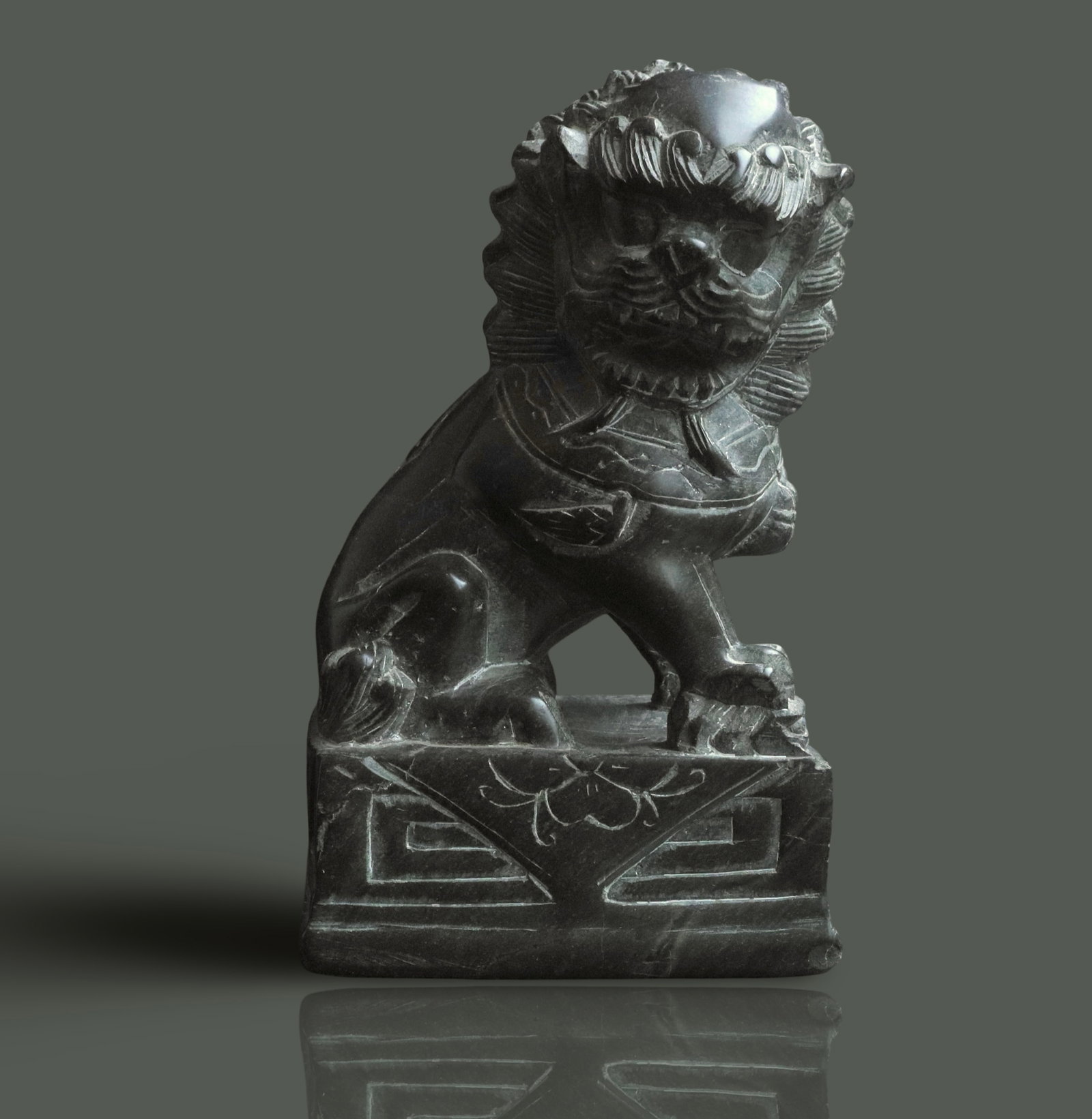 Chinese Foo Dog Sculpture: This item is a vintage Chinese Foo Dog sculpture, likely hand-carved from black stone or soapstone. Design: Features a stylized lion creature seated on a rectangular base, often decorated with floral