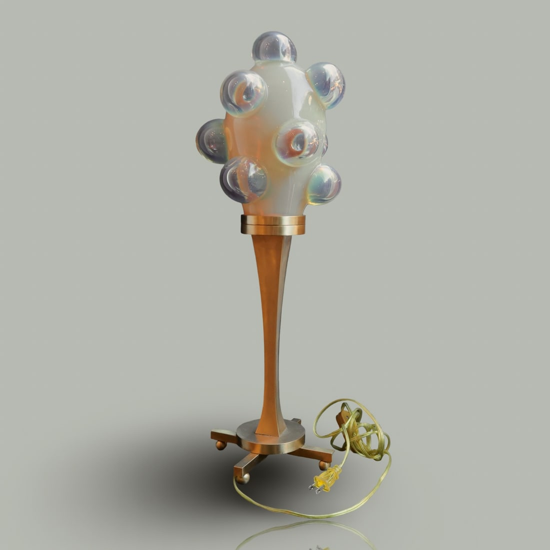 Decorative Lamp by Andrew Rokosh: Artist: Andrew Rokosh A unique decorative table lamp with a sculptural design. An artistic combination of glass and metal. The base is made of hand-finished brass with a golden hue, shaped like a slen