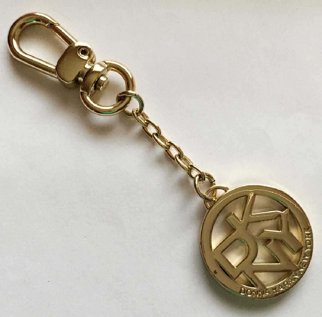Donna Karan New York gold plated key chain. Length 4: Donna Karan New York gold plated key chain. Length 4 3/4". Round part with letters DKNY measured 1 1/4" in diameter. Condition excellent.
