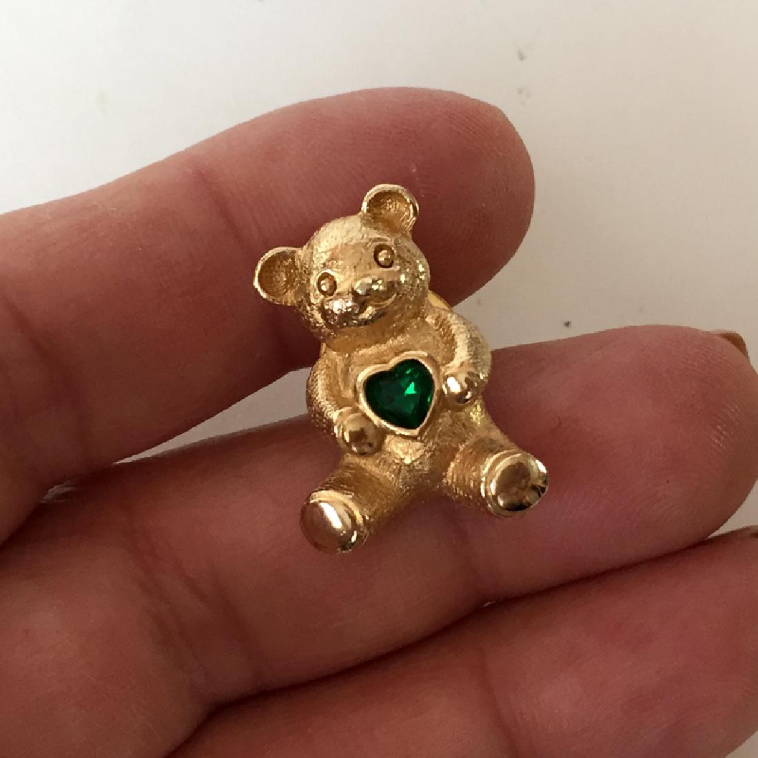 AVON: Gold plated textured BEAR shaped tie pin with: AVON: Gold plated textured BEAR shaped tie pin with emerald green heart shaped bezel set stone. Length 1". Condition excellent.