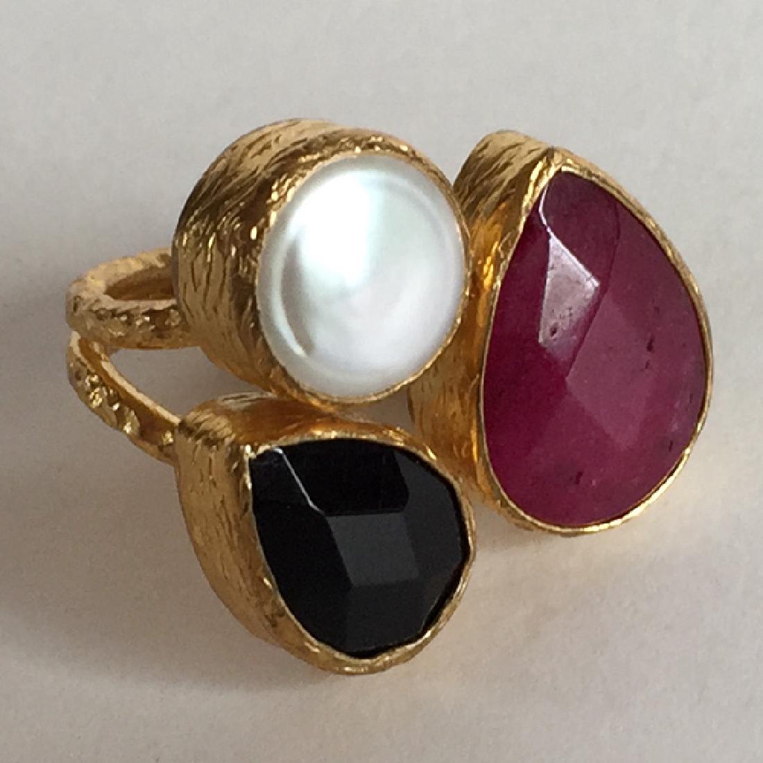 Gold plated textured finish ring with channel set pear: Gold plated textured finish ring with channel set pear shape ruby and sapphire color semi-presious stones and round white mother of pearl. Size 7. Signed TIKLARI. Ruby and sapphire color stones are ch