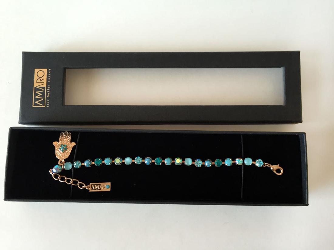 AMARO: Gold plated prongs set round teal, blue color: AMARO: Gold plated prongs set round teal, blue color faceted and cabochon stones lobster clasp tennis bracelet with HAND and LOGO charms. Length 6 1/2" plus 1" extension. Condition excellent, comes i