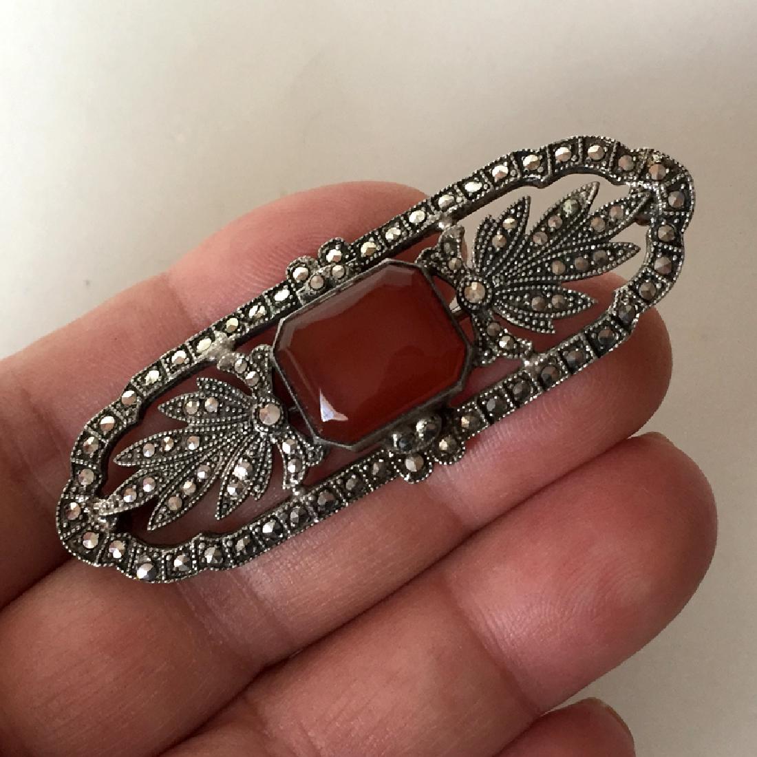 Sterling silver black antique finish brooch with: Sterling silver black antique finish brooch with genuine carnelian and marcasites. Weight 10.7 grams. Hallmarked STERLING. Measured 2 1/2" in length. Condition excellent. 25