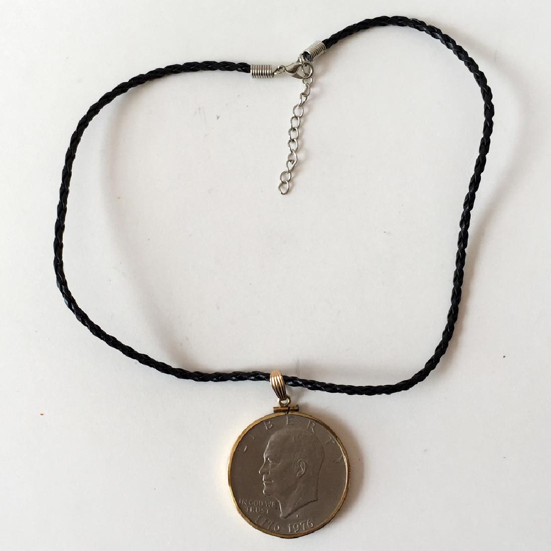 Vintage EISENHOWER uncirculated $1 LIBERTY coin: Vintage EISENHOWER uncirculated $1 LIBERTY coin 1776-1976 set in gold plated bezel with loop - pendant and black braided leather cord with silver tone lobster clasp. Length of pendant with bail 2 1/8"