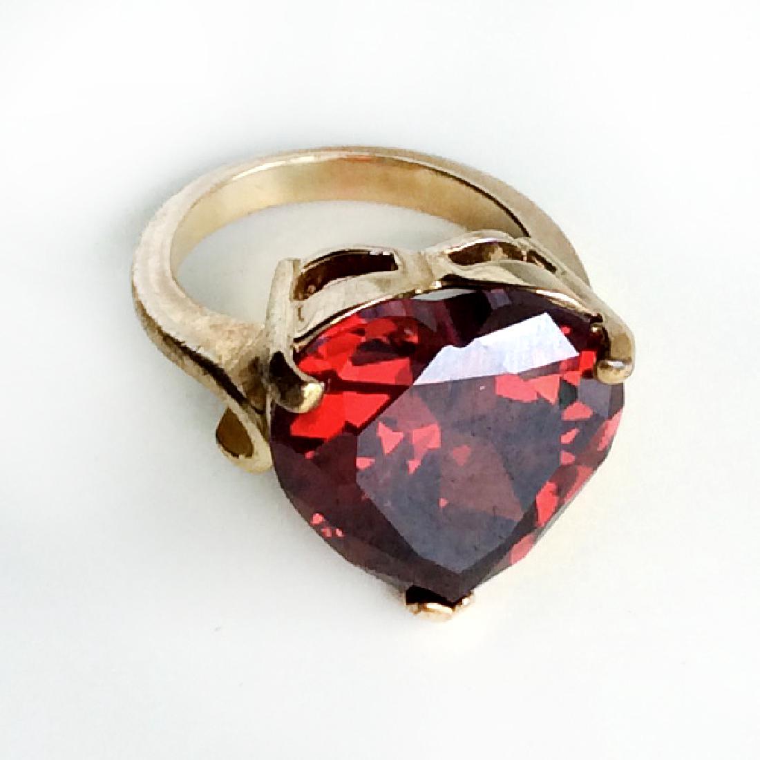 Gold tone heart shaped prongs set faceted garnet color: Gold tone heart shaped prongs set faceted garnet color ring. Size 6. Condition very good.