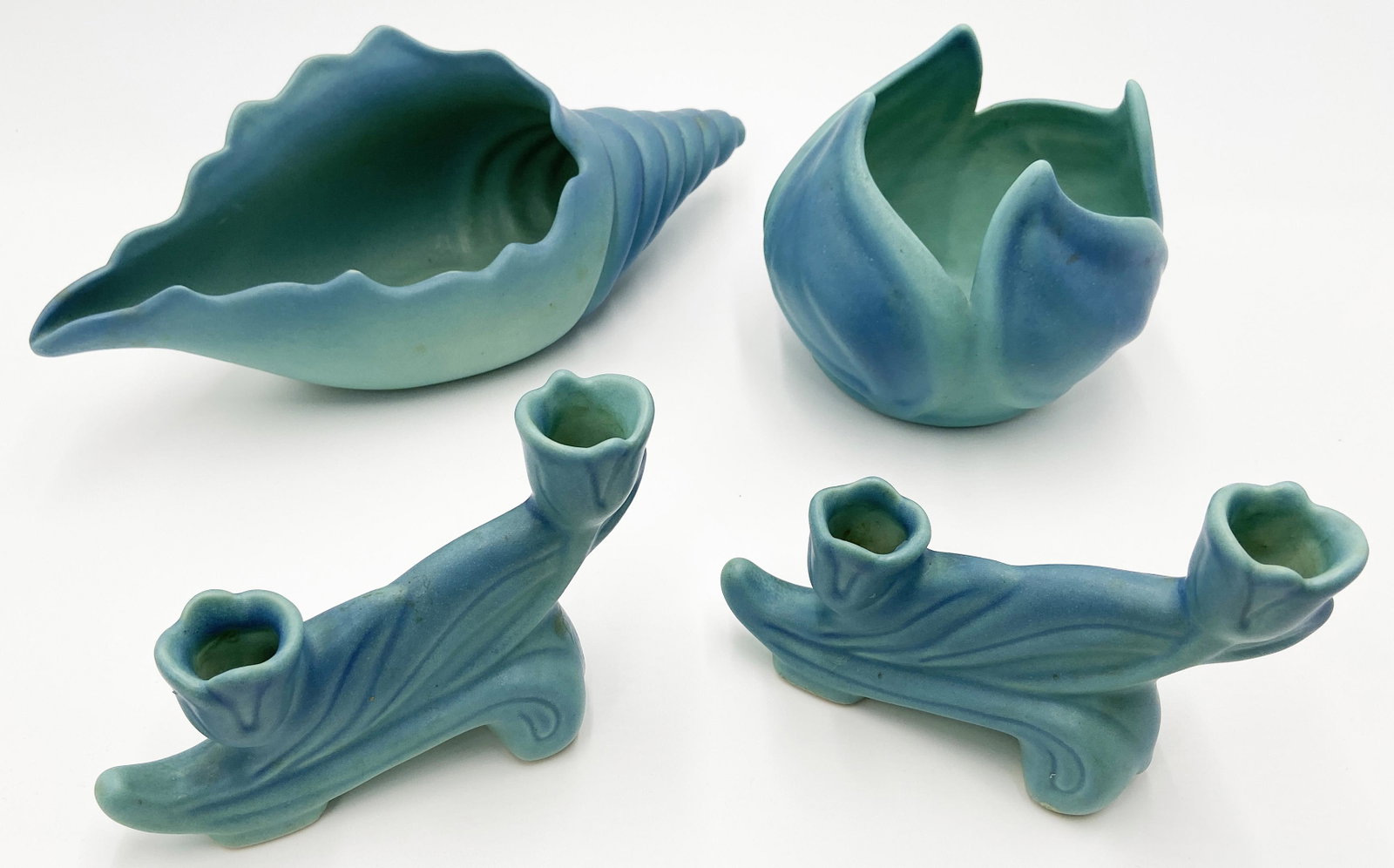 Lot: 3 Pcs. of Van Briggle Pottery.: A conch seashell, a vase, and a pair of candleholders. The conch shell measures 13" wide, the vase measures 5" tall, and the pair of candleholders measures 4 1/2" tall.