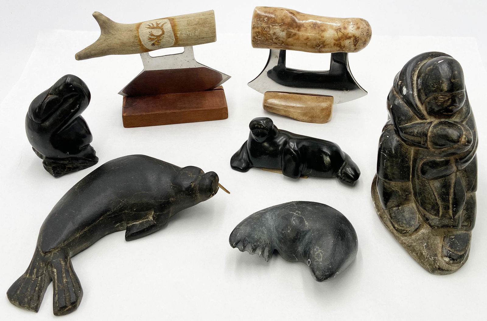 Lot of Inuit Eskimo Carvings.: Includes: 5 Stone Carvings, a Deer horn Chopper, and a fossilized oosik (Walrus Penis) Chopper. The lg. walrus is missing one wood tusk. A $30 export permit is required by the buyer if the fossilized