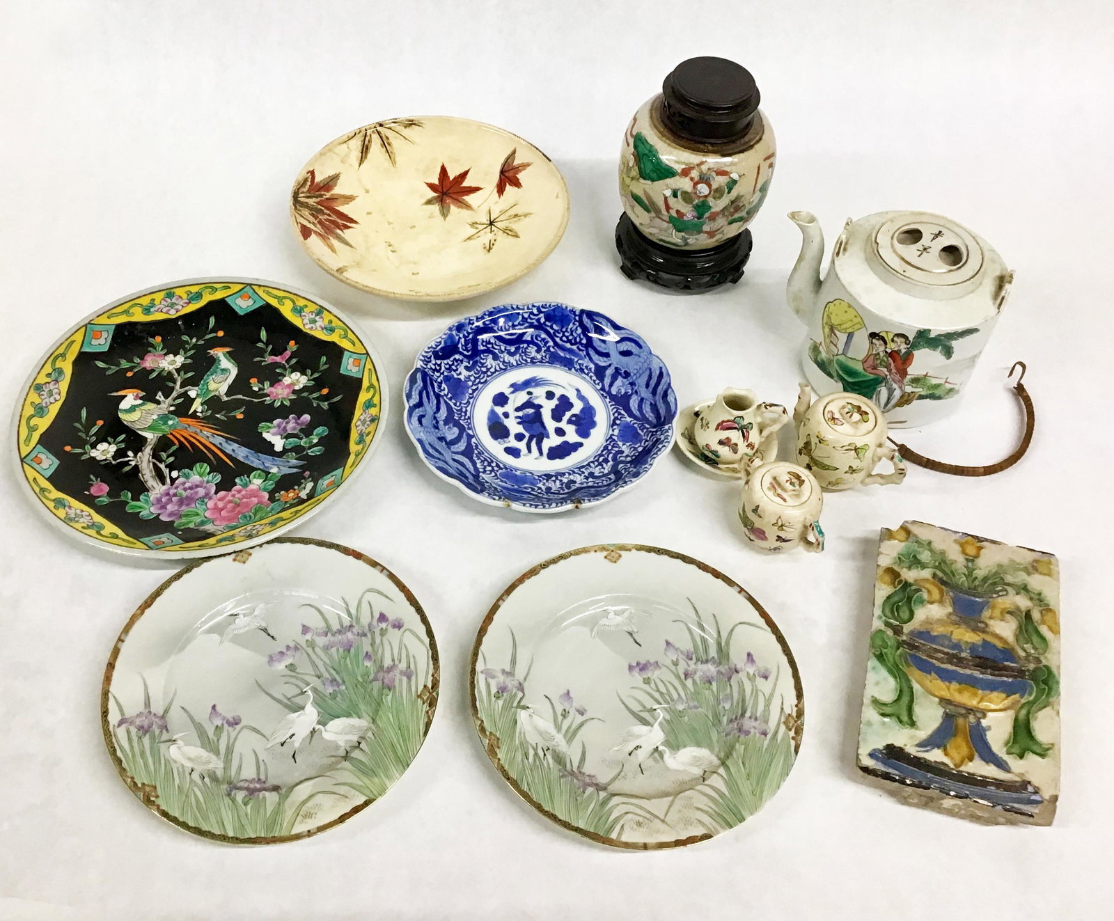 Lot of Asst. Oriental Porcelain Items.: Mostly Chinese & Japanese. An Old Tile, 5 Plates, a Teapot, a Covered Jar, and a 3 Pc. Miniature Tea Set. The Plates Range in Size from 8 1/2" to 11" in Diameter. The Teapot Measures 5 1/4" Tall. Thir