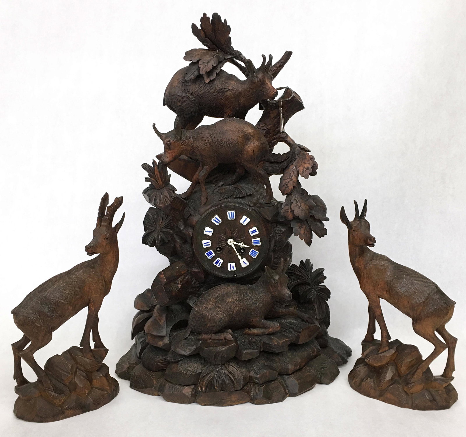 Antique Swiss Black Forest Carved Clock w/Deer.: In Excellent Condition, Except one of the Separate Side Deer Figures has an Ear Broken off and is Missing. The Clock Measures 23" Tall. The Deer Figures Measure 13" Tall and 12 1/2" Tall. The Clock ha