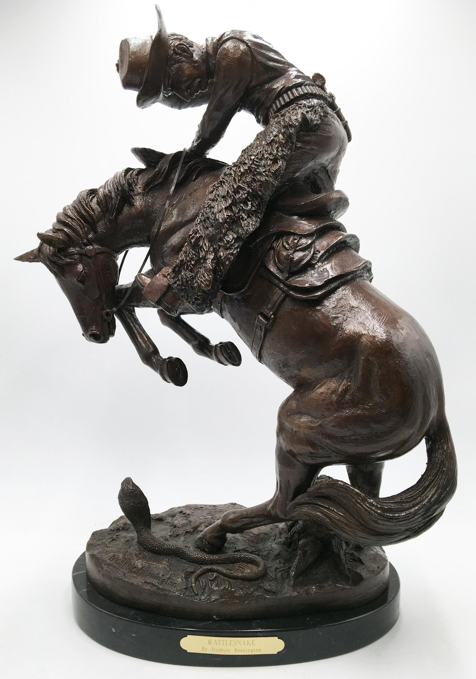 Bronze Frederic Remington Sculpture.: Titled "Rattlesnake". On a Marble Base. Measures 22" Tall. This Sculpture has a Shiny Brown Painted Coating over the Bronze Metal. Third-Party Shipping Required.