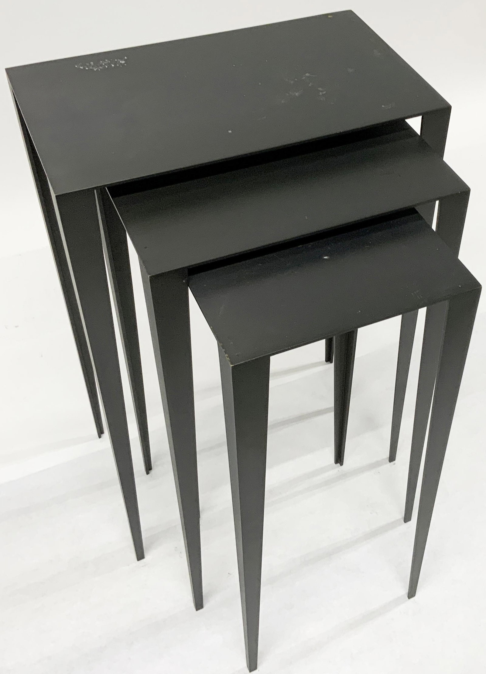 Set of 3 Modern Bronze Nesting Tables.: With a Grey Finish. Tables have Some Scratches and Wear. The Largest Table Measures 29" High, 18 3/4" Wide, and 11" Deep. They are Very Heavy. Third-Party Freight Shipping or Personal Pickup Required.