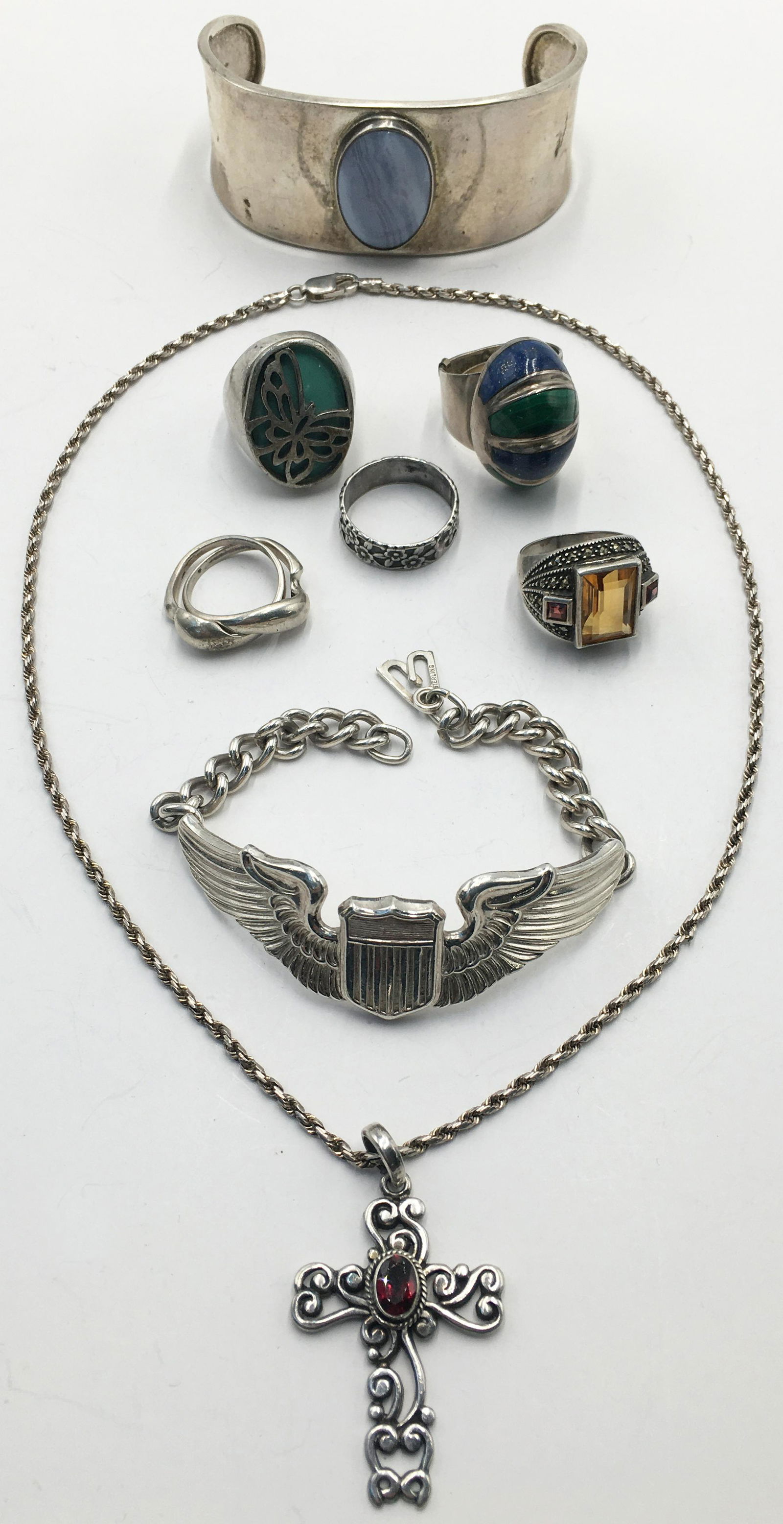 Lot: Mostly Sterling Silver Jewelry.: Includes: An Air Force Bracelet, A Bangle with Greyish-White Stone, A Marcasite Ring with Orange Stone and Garnets, A Cross on Chain with Garnet, a Lapis and Malachite Ring, etc.
