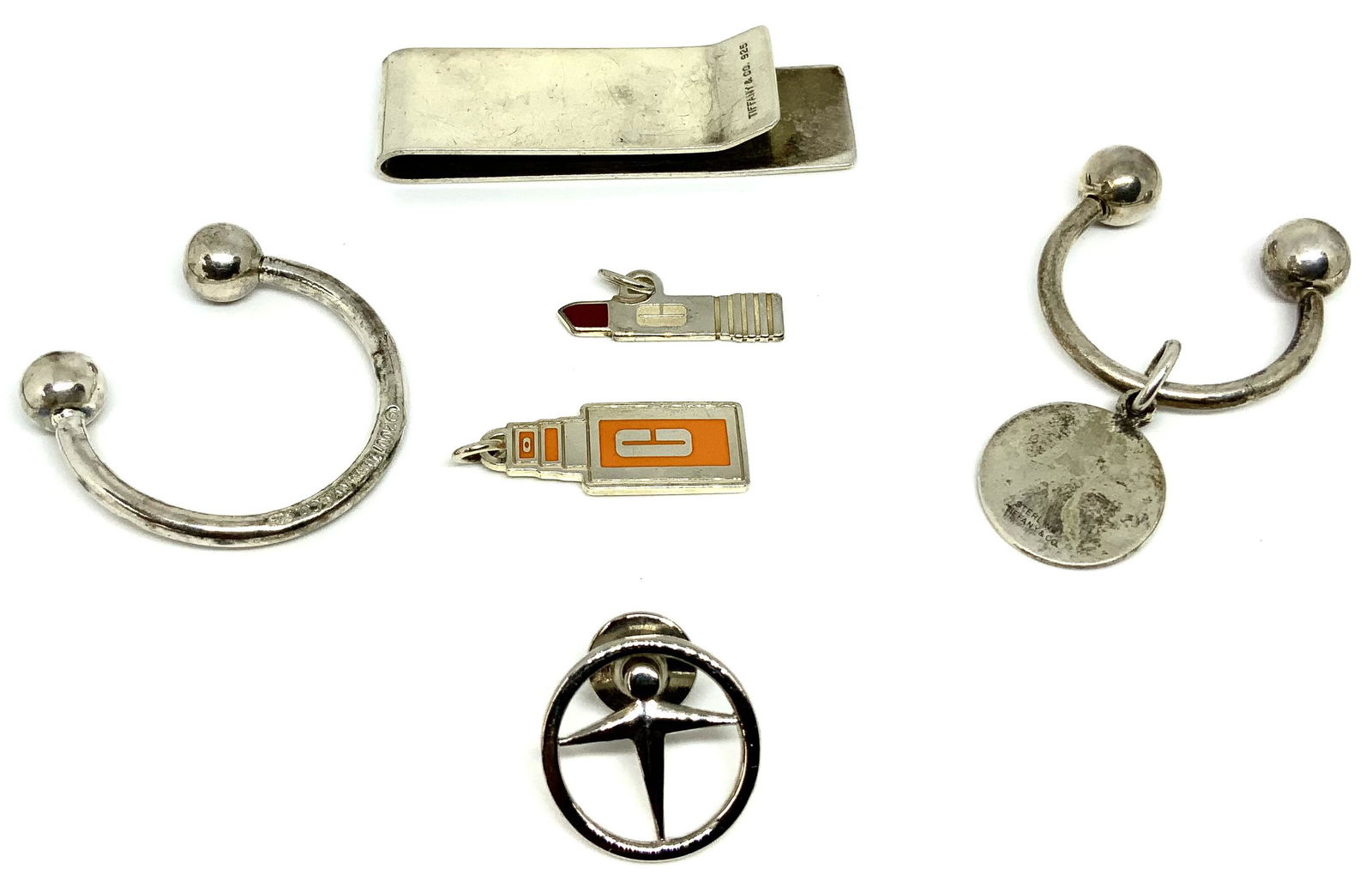 Lot: 6 Pcs.: Tiffany & Co. Sterling Items.: 2 Keychains, a Tiffany Money Clip (Bent Front), 2 Tiffany Silver Corporate Charms, and Tiffany Sterling Tie Tack.