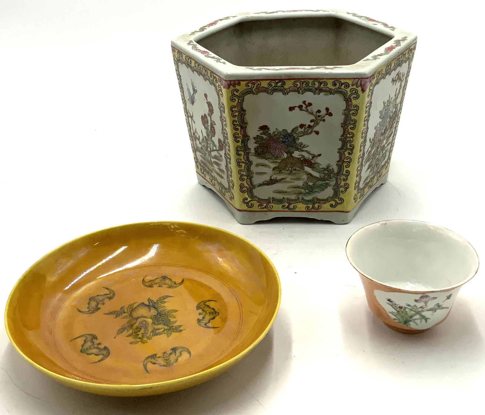 Lot: 3 Chinese Porcelain Items.: An Antique Chinese Cup (As Is, Chipped on the Edge and has a Crack). Also, an Orange Dish with Bat Decorations (8 3/4" Diameter, 1 3/4" Tall), and a Jardiniere or Planter (7" Tall, 9 1/4" Diameter). T