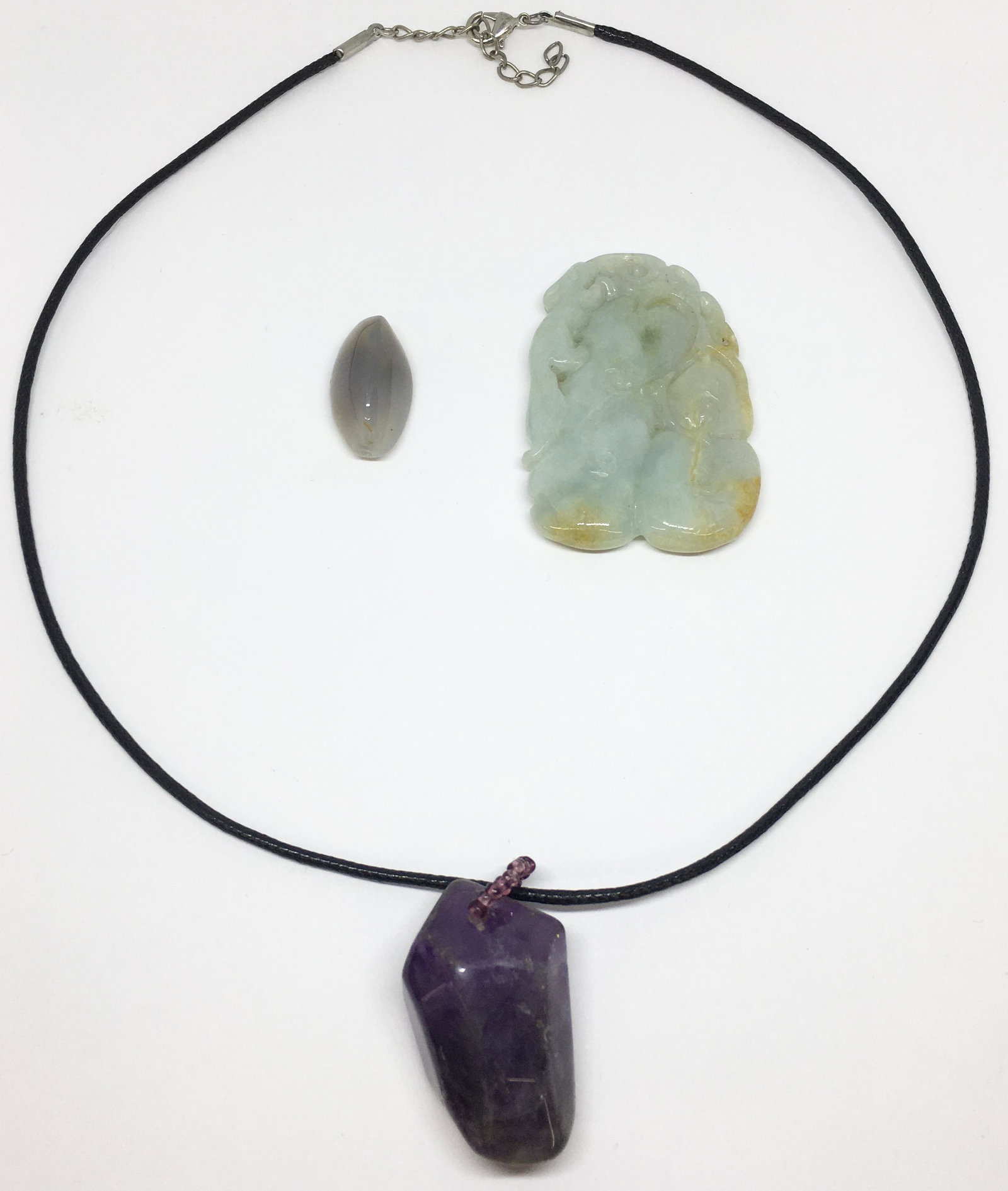 Lot: 3 Pcs. of Stone Jewelry - Jadeite, etc.: Includes a Carved Asian Jadeite Piece or Pendant (2 1/16" Long, 1 3/8" Wide), a Polished Amethyst "Chunk" Pendant on a Cloth Cord Necklace (Amethyst Pendant Measures 1 3/8" Long), and a Polished Stone