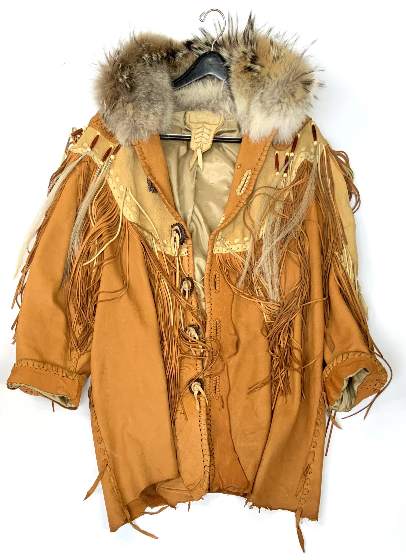 Outstanding Leather Fringed Coat with Fur Collar.: By Grizzly. Has Carved Mother-of-Pearl Pieces on the Shoulders and a Carved Eagle Mother-of-Pearl Emblem on the Back. Has Wood Beads with Horsehair, and Deer Antler Buttons. The Collar Appears to be C