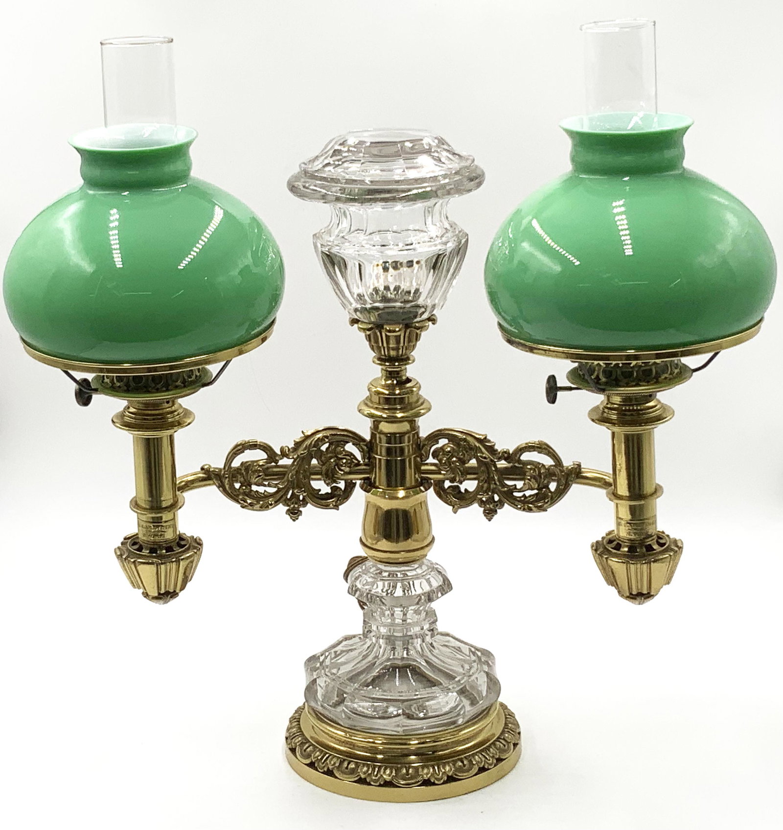 Sgd. B. Gardiner Brass & Crystal Double Lamp.: Made by Baldwin Gardiner. Electrified. Very Ornate, and In Very Good Condition. Sgd. "B. Gardiner, N.York". Measures 22 1/2" Tall to the Top of the Hurricane Shades, and 21" Wide. Third-Party Shipping