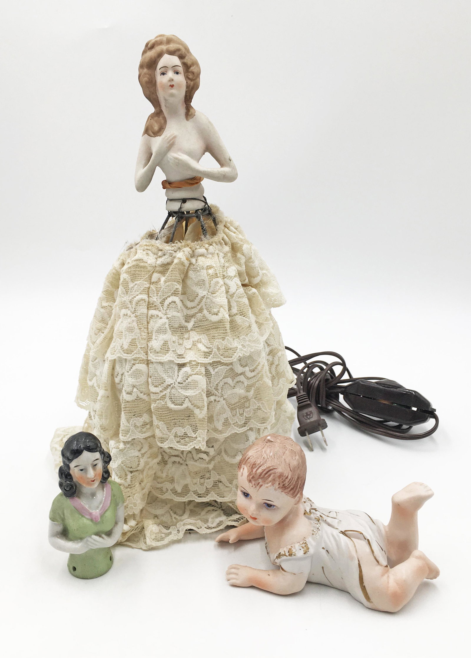 Lot: 3 Pcs.- 2 Porcelain Half Dolls & Piano Baby.: One of the porcelain dolls has been fitted as a lamp; she is 12.5" tall. Third-Party Shipping or Personal Pickup Required.