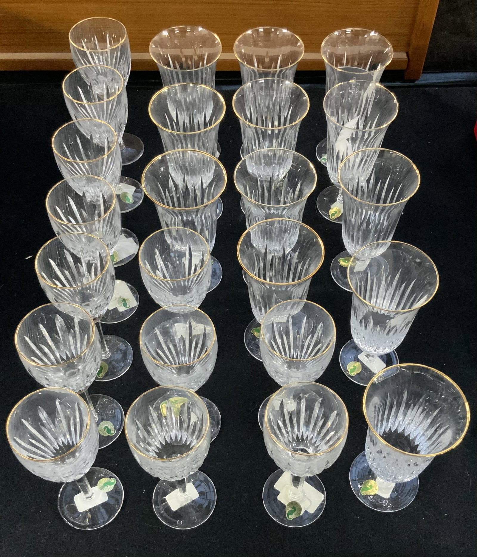 Lot: 24 Pcs. of Waterford Crystal Stemware.: "Golden Carina" Pattern, both Wine Glasses & Iced Beverage Glasses. Never Used, with Original Labels. Includes 3 Original Waterford Crystal Boxes, and Original Waterford Wrapping Paper. The Stemware M