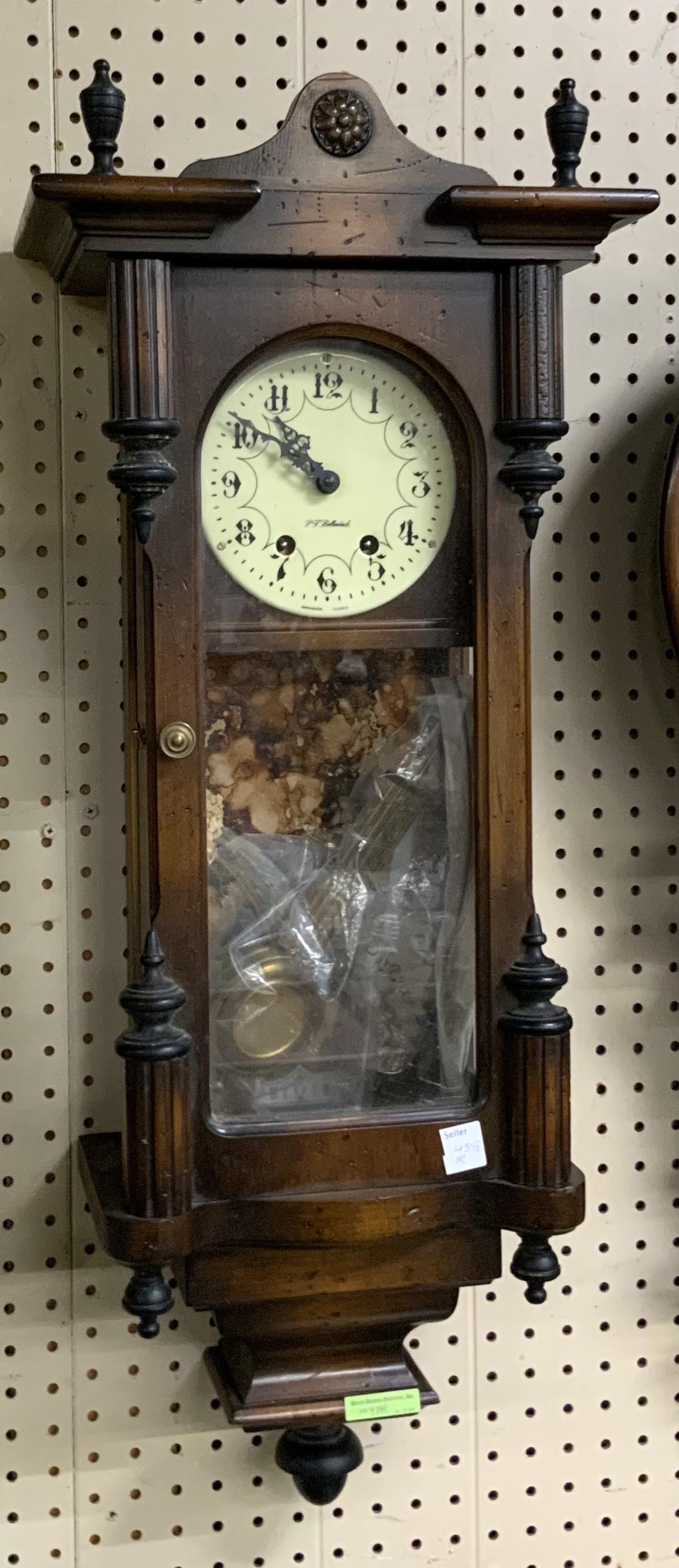 Long Case Wall Clock sgd. P.T. Bollenbach.: With Columns and Finials on the Top. Measures 33" Long, 13" Wide, and 8" Deep. Third-Party Shipping or Personal Pickup Required.