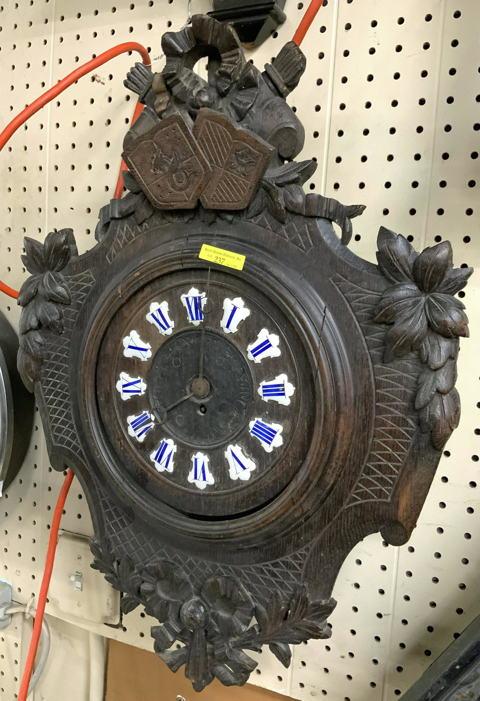 Carved Black Forest Wall Clock w/ Coats of Arms.: Working condition unknown. Measures 24" tall, 17.5" wide x 4" deep. Third-Party Shipping or Personal Pickup Required.