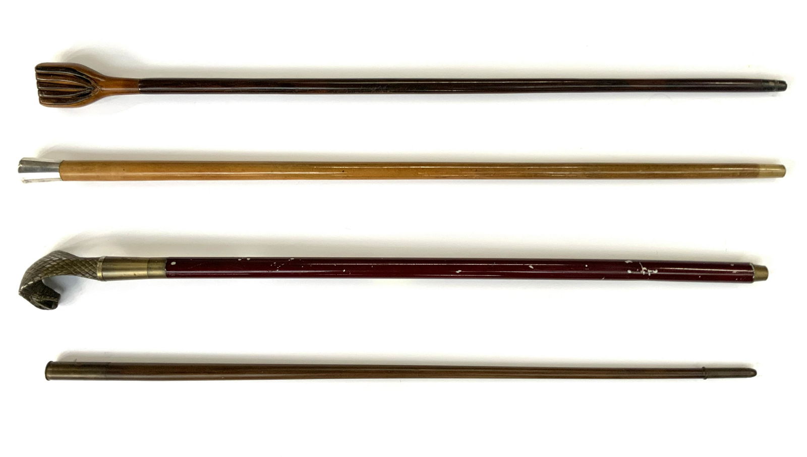 Lot of 4 Interesting Canes.: Lot of 4 Canes including a cobra head with a sword inside, 35" Long; Musical head cane, Sterling handle Cane, and Bullet Head and Bottom Cane. Third-Party Shipping or Personal Pickup Required.