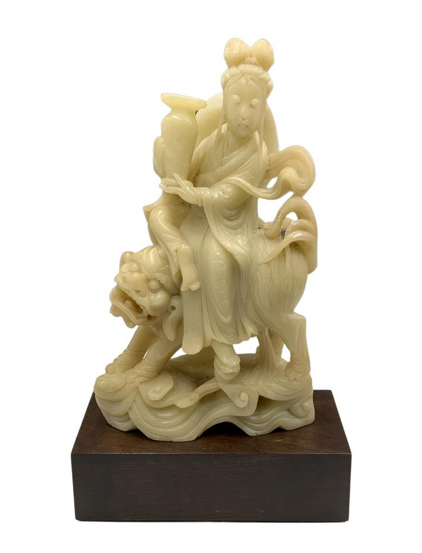 Carved Chinese Soapstone Figure - Woman on Foo Dog: Has some White Wear Spots / Nicks on Front and Back. On a Wooden Stand. Measures 16 1/2" Tall, inc. the Stand. The Figure Measures 8" Wide.