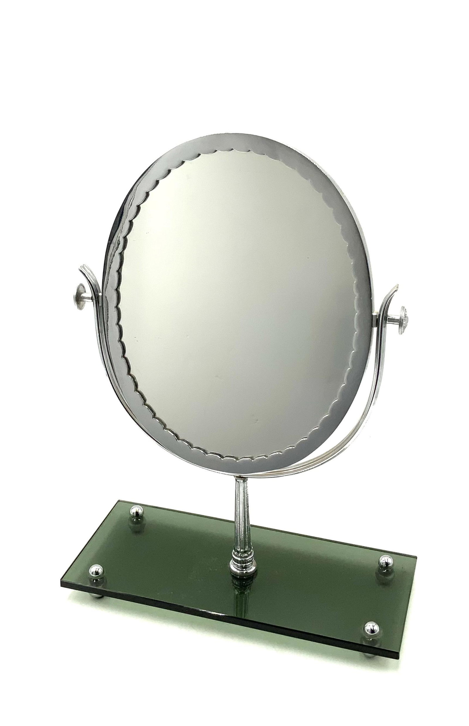 Chrome Art Deco Style Make-Up Mirror.: Circa 1950's-1960's. With a Smoke Glass Base. The Base Measures 13" Wide and 5 1/2" Deep. The Mirror Stands 18" Tall. Third-Party Shipping or Personal Pickup Required.