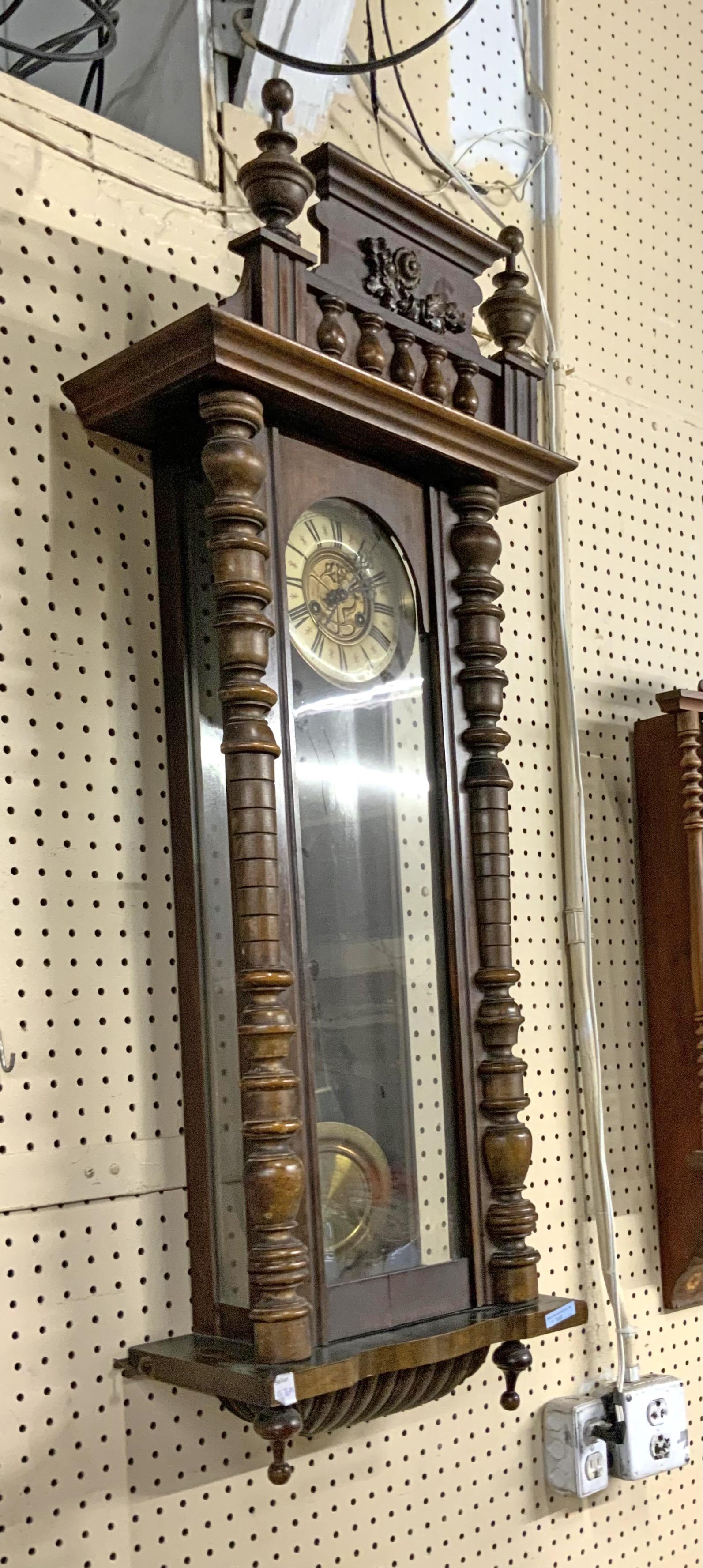 Beautiful Mahogany Carved Wall Clock.: With Carvings on Top and a Pair of Finials. Working Condition is not Known. Measures 44" Tall, 16" Wide, and 8" Deep. Third-Party Shipping or Personal Pickup Required.