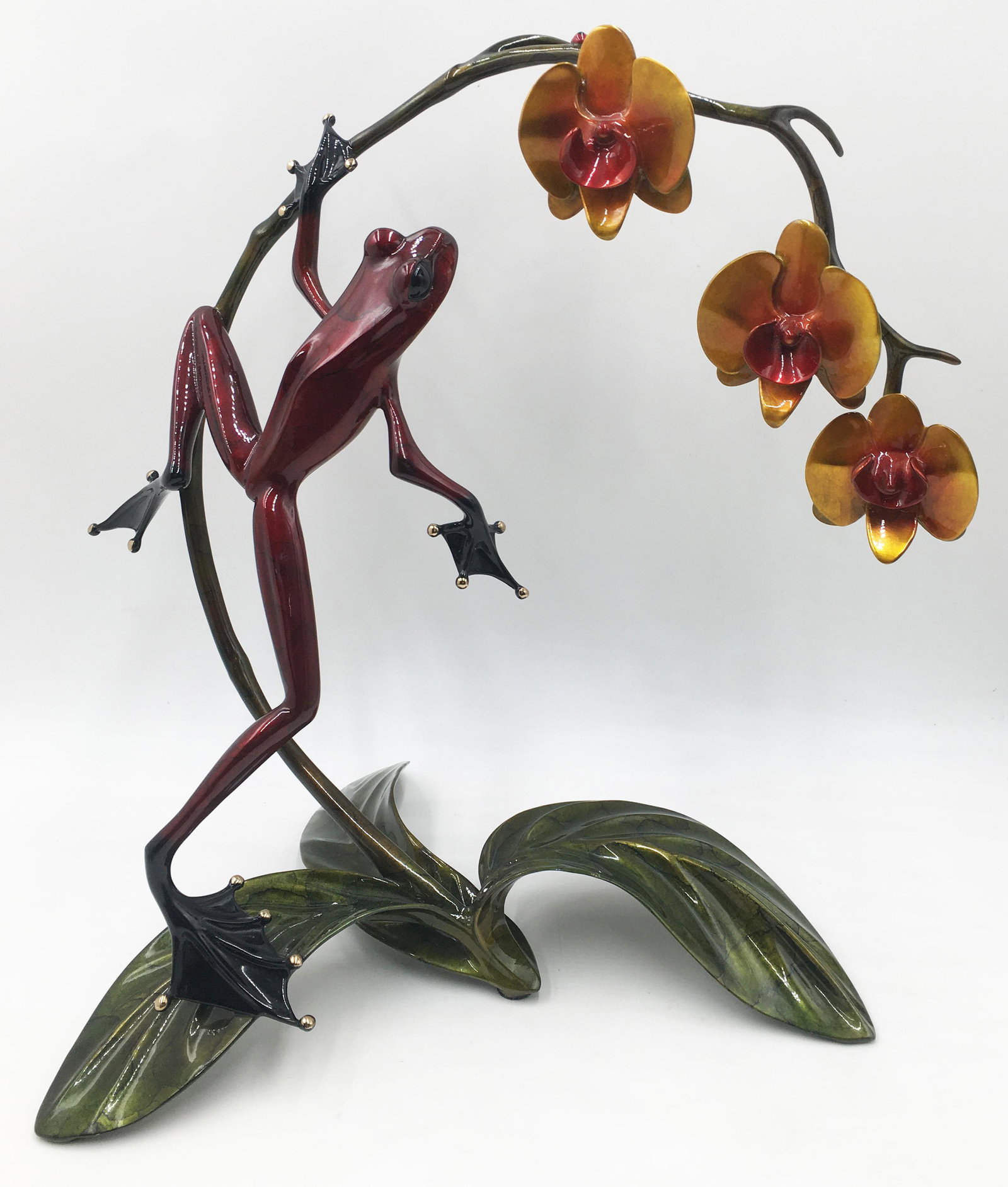 Large Tim Cotterill Bronze Frog w/ Orchids.: Quite tall and heavy. Nice condition overall, with small areas of enamel loss noted on the leaves, stem, and frog's legs. There is also a tiny white spot on the frog's back. Measures 15.5" tall, 14.5"
