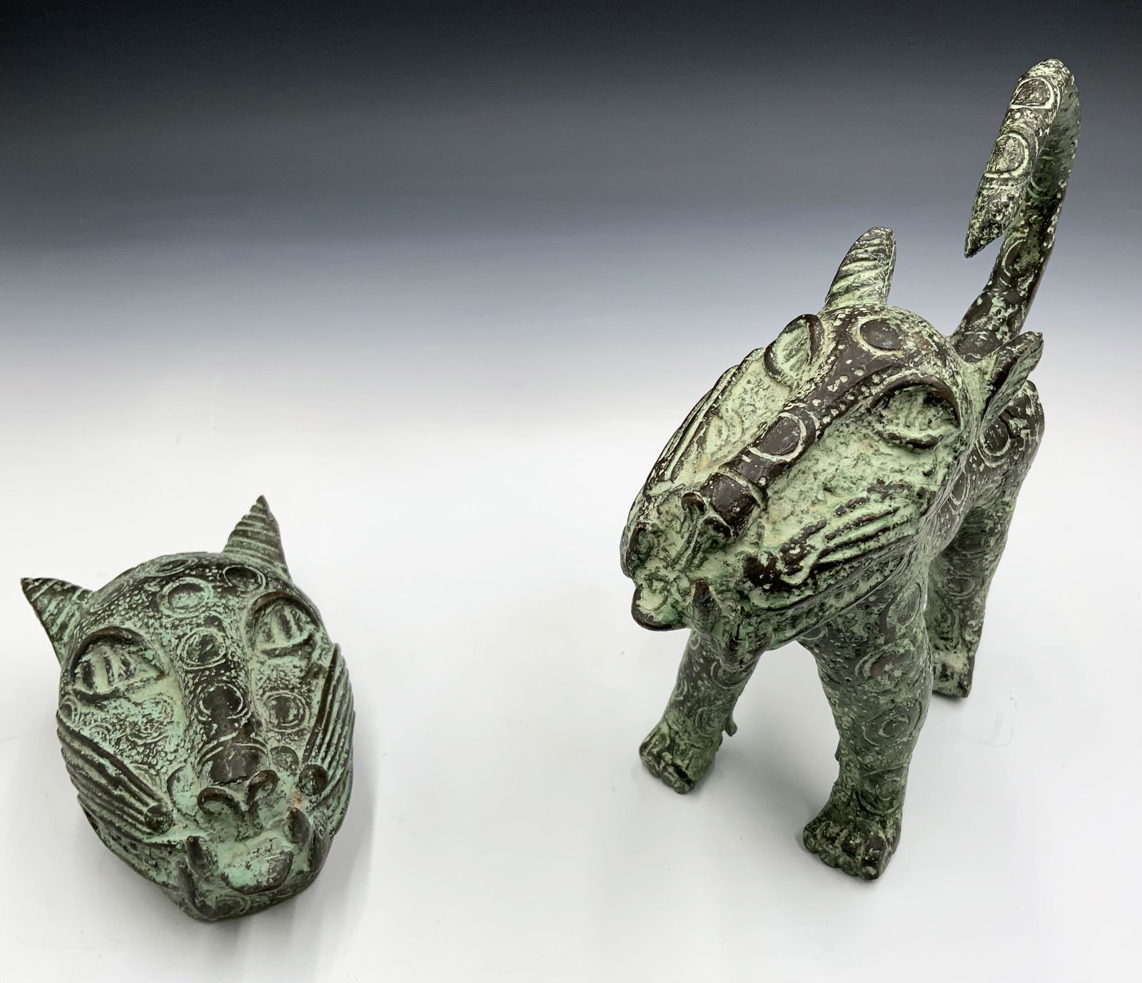 Lot of 2 Benin Bronze Leopard Figures.: One is a whole leopard, the other is just the head. Nice condition overall; the larger figure has chipping near the chin. The larger figure is 8.5" tall. Third-Party Shipping or Personal Pickup Requir