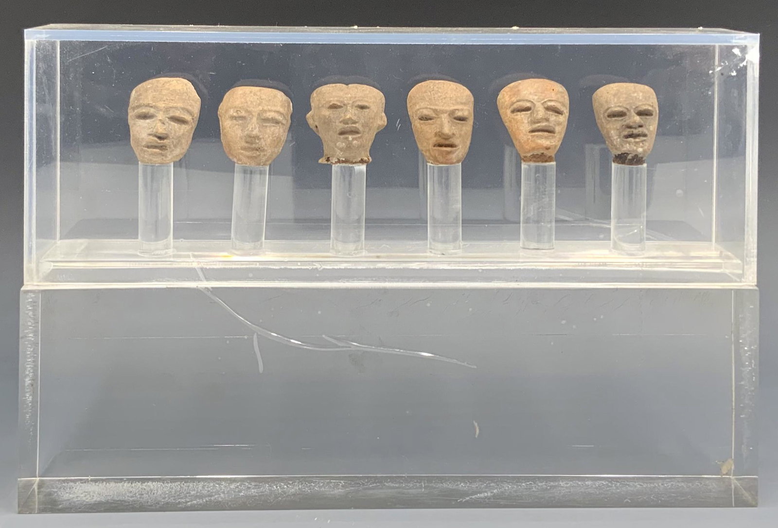 Set of 6 Clay Pre-Columbian Tiny Heads.: In a Lucite Display. There is Tape Holding the Display Together. The Heads Measure Appx. 1" Tall.