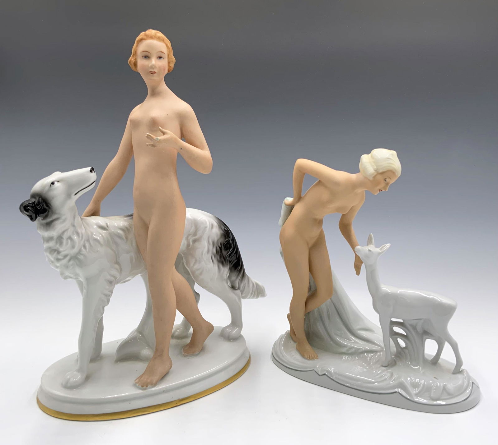 Lot of 2 German Nude Figurines w/ Animals.: The nude w/ dog figure is marked, "Gerold", and the lamb figure is marked, "Schau Bach Kunst". The Gerold figure is the taller of the two, at 11.5", and is missing a finger. Third-Party Shipping or Pe