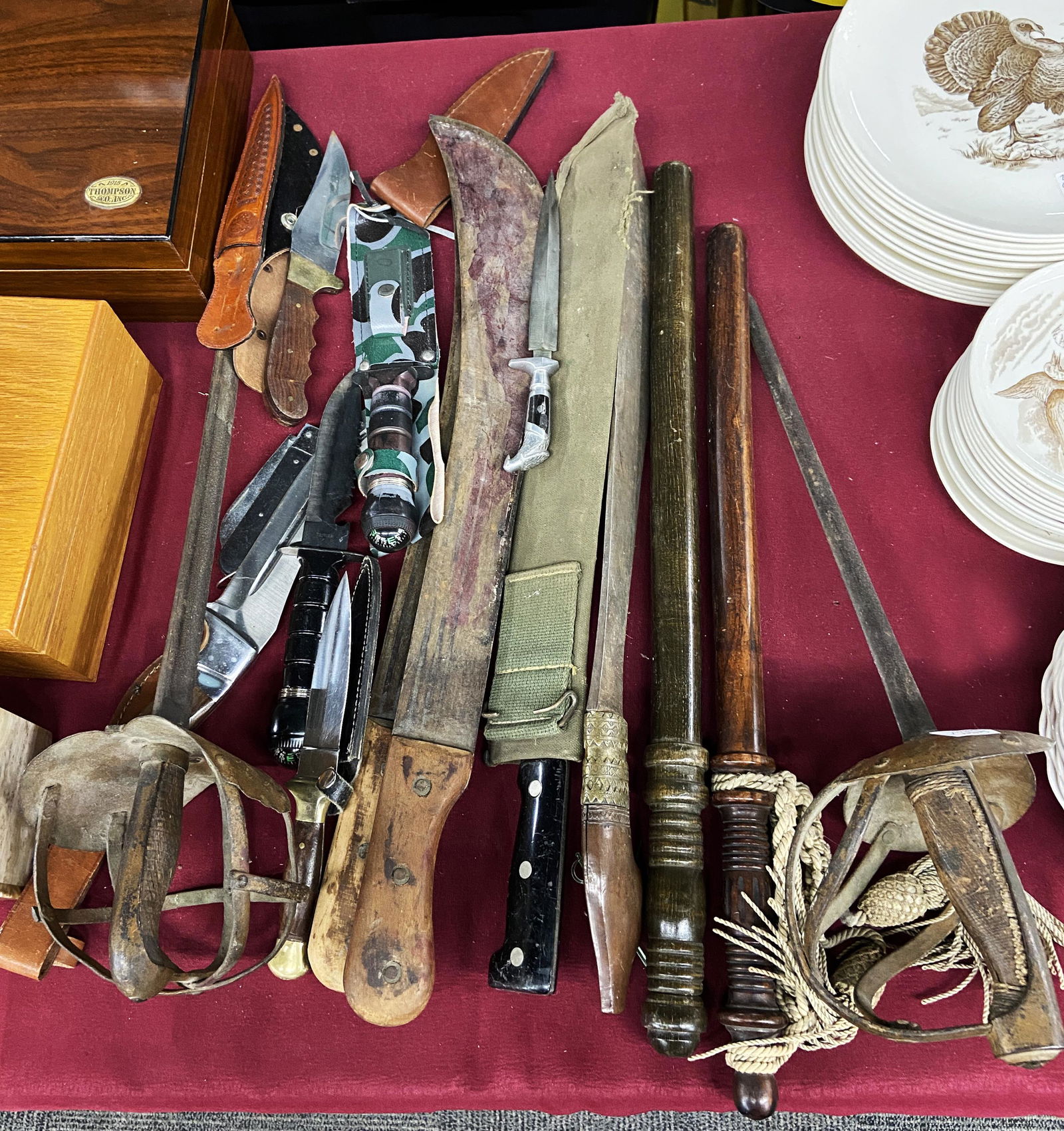 Lot of Assorted Weapons- Knives, Clubs, Machetes.: Some are older, some are modern pieces. Condition varies- some blades are very clean, others have discoloration and rust. One of the machetes is marked, "Sheffield England". The longest weapon in the