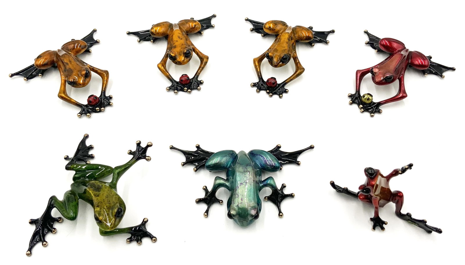 Lot: 7 Small Tim Cotterill Bronze Frog Sculptures.: All are Signed and Numbered. Four of them have ladybugs, one looks like he is Waving, one is Reaching, and one is Crouching. They look to be in Nice condition overall. The Crouching frog has some enam