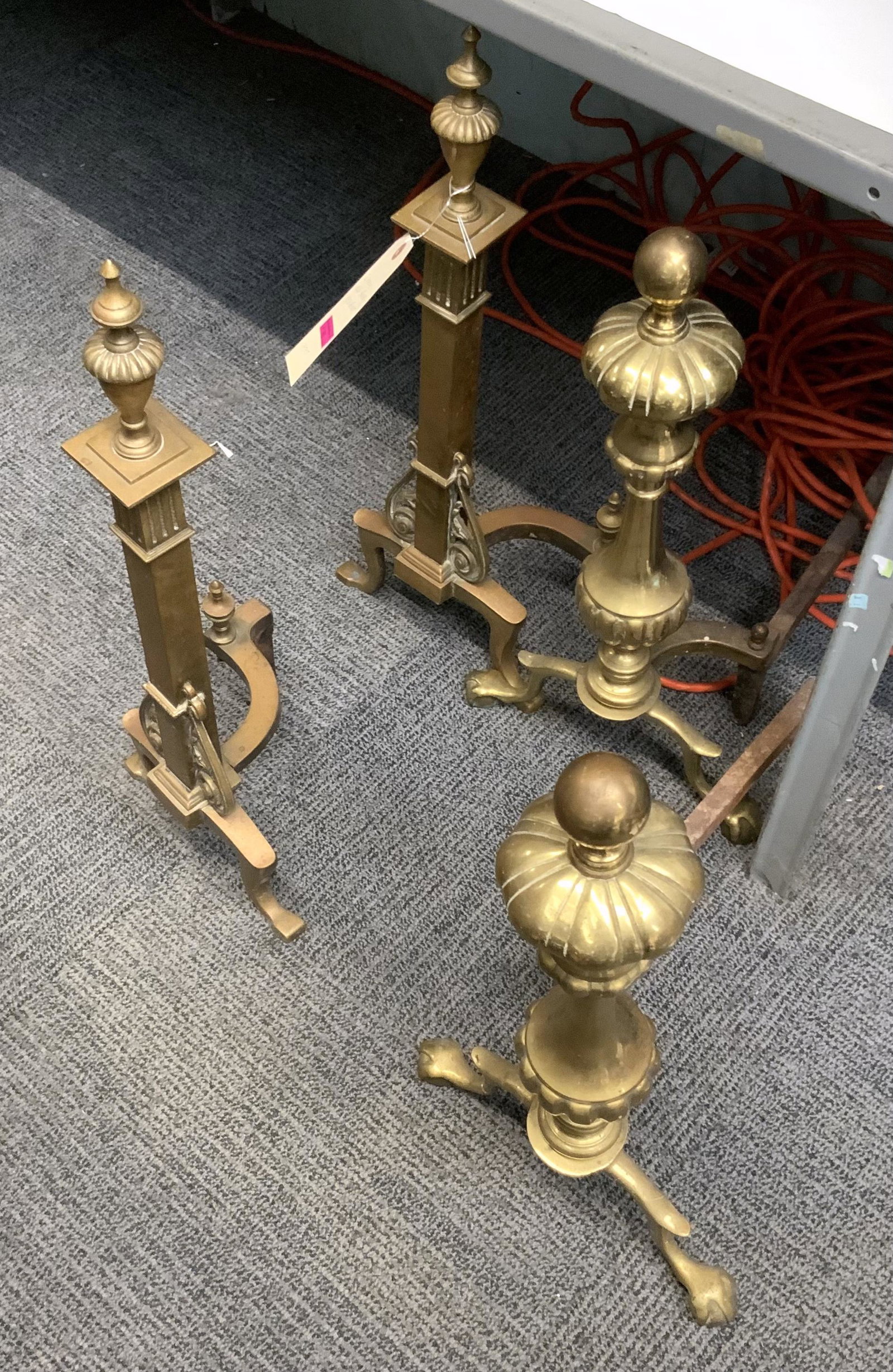 Lot: 2 Pairs of Old Brass Andirons.: The taller ones measure 24" tall. The shorter ones actually contain a fair amount of iron, and are a bit heavier than the taller ones. The shorter ones have Claw Feet. Third-Party Shipping or Personal