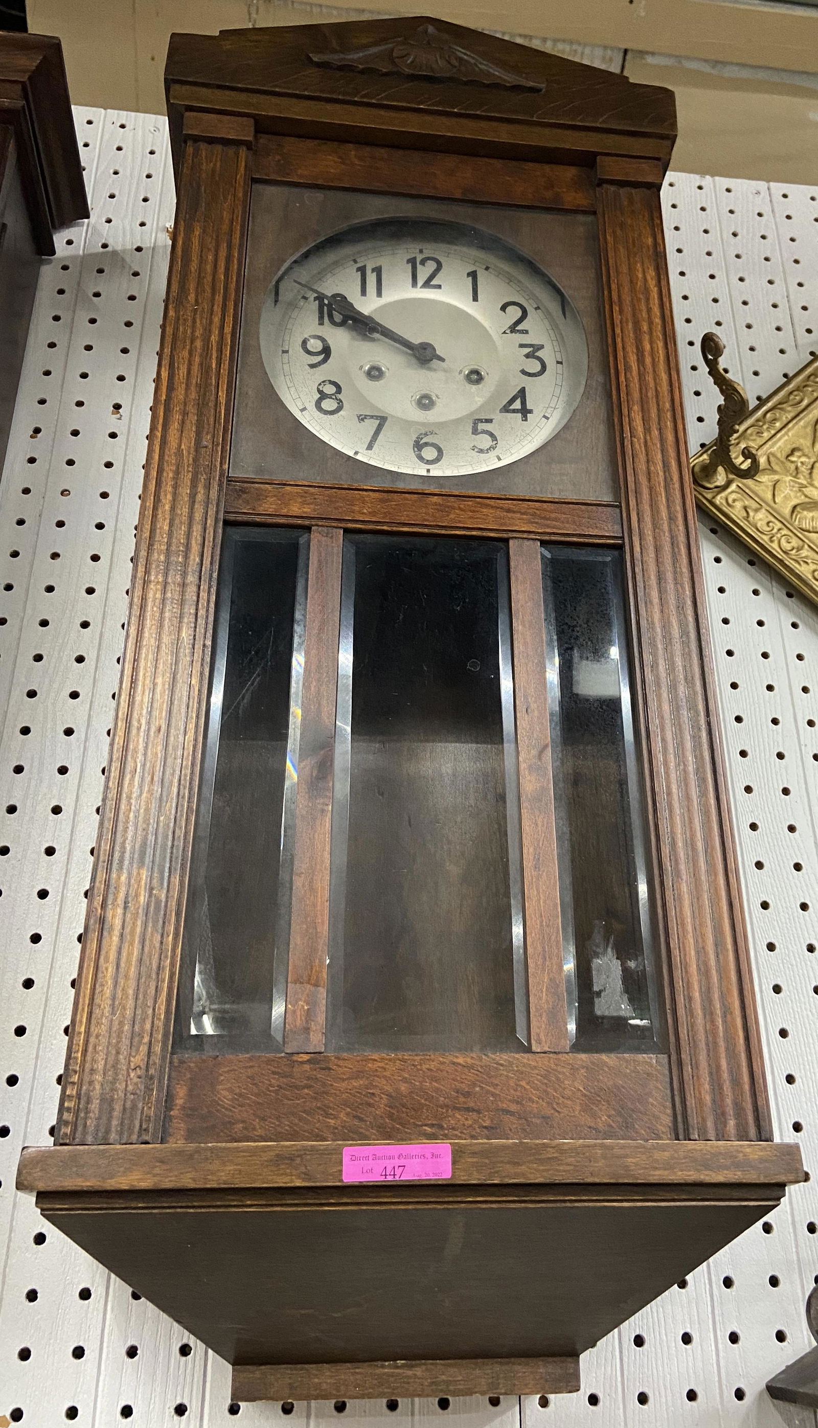 European Mission-Style Oak Wall Clock.: This clock is in an oak case with bevelled glass panels on the door. The case appears to be in good condition, the movement is untested, and the pendulum is missing. The Clock Measures 13" wide, 7" de