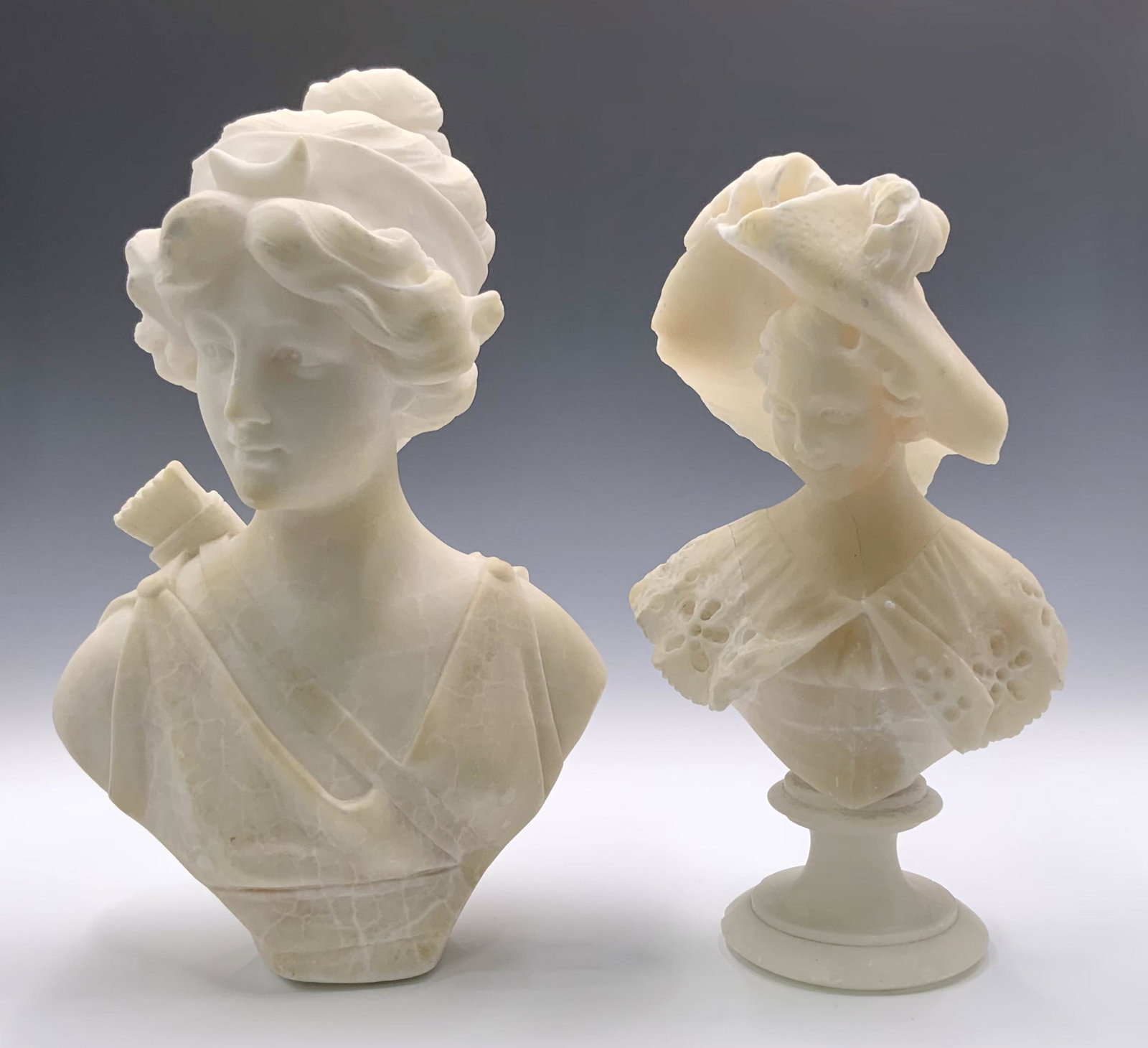 Lot: 2 Antique Alabaster Busts of Ladies.: The larger one measures 10" tall, and has no attached base. Both ladies have several small Chips. Third-Party Shipping or Personal Pickup Required.