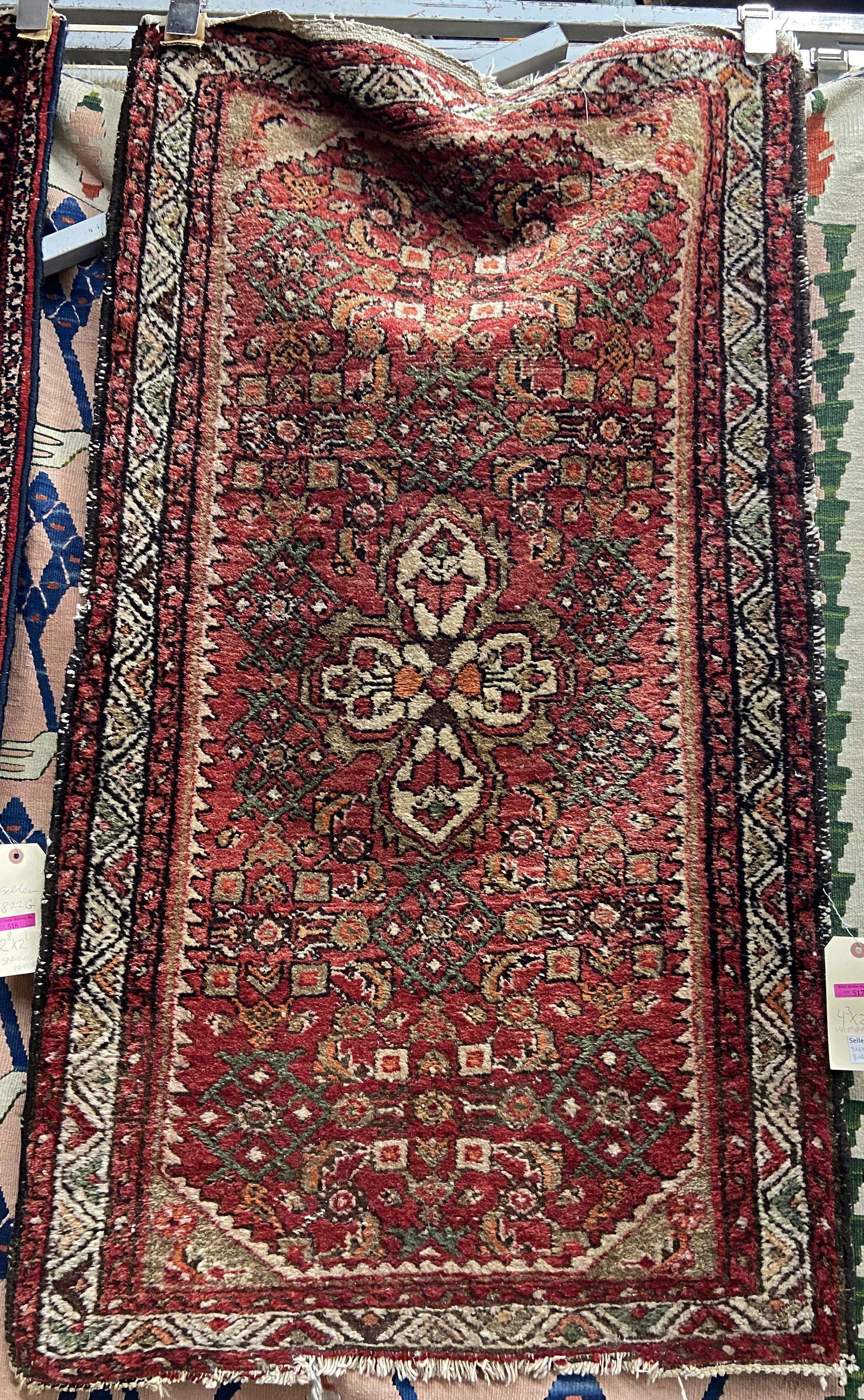 4' 3" by 2' 6" Hand-Made Oriental Rug.: This Hamedan (?) rug has a red field with a center medallion, and a geometric pattern overall. It is evenly worn, but has damage with fringe missing. It is Still a very useable rug. In-House Shipping