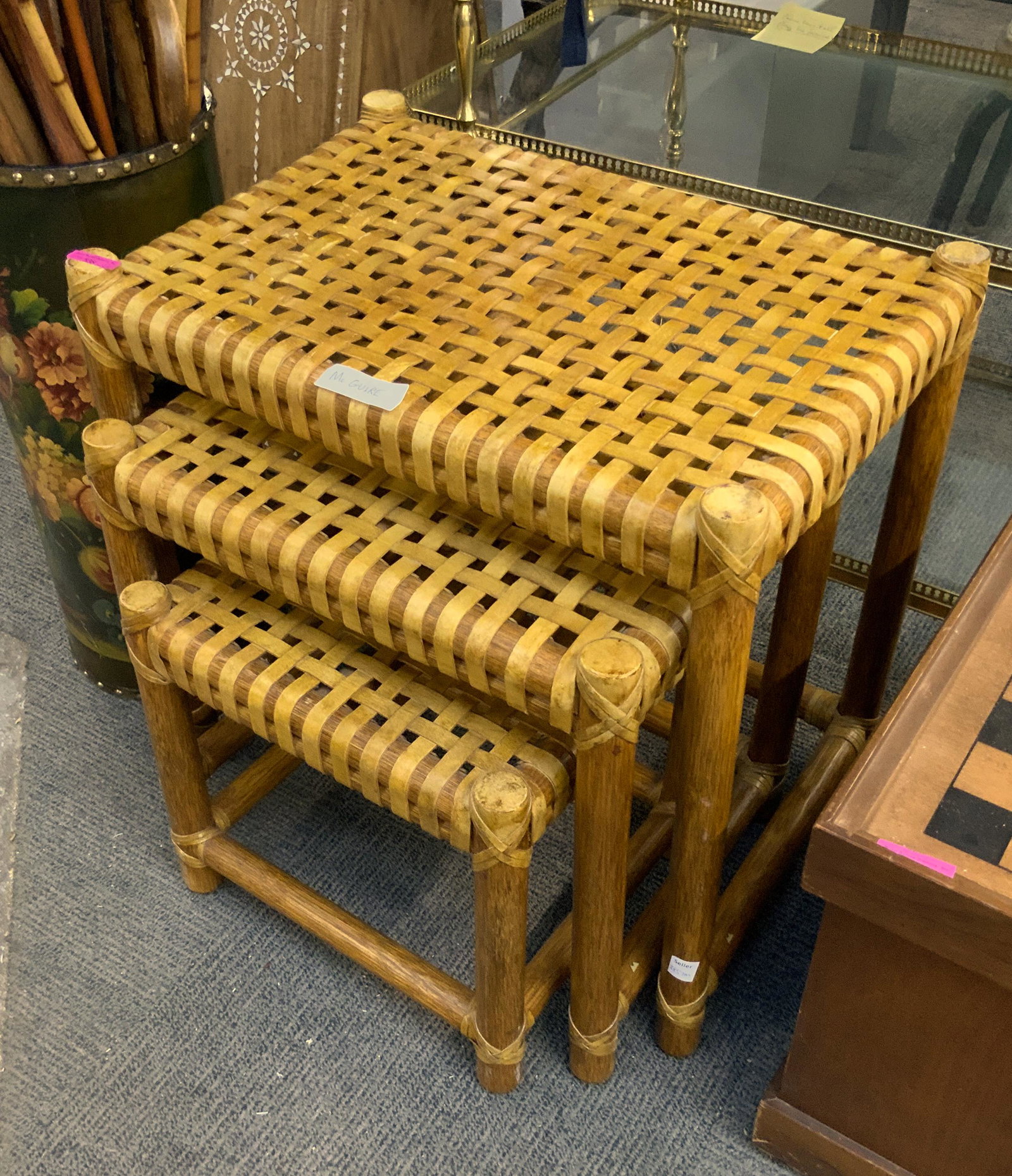 McGuire Bamboo & Leather Nest of 3 Tables: Made by McGuire of California (and Signed), this set of nesting tables appear to be in Good overall condition, with no damage to the bamboo or the leather strapping. There is a small area on the large