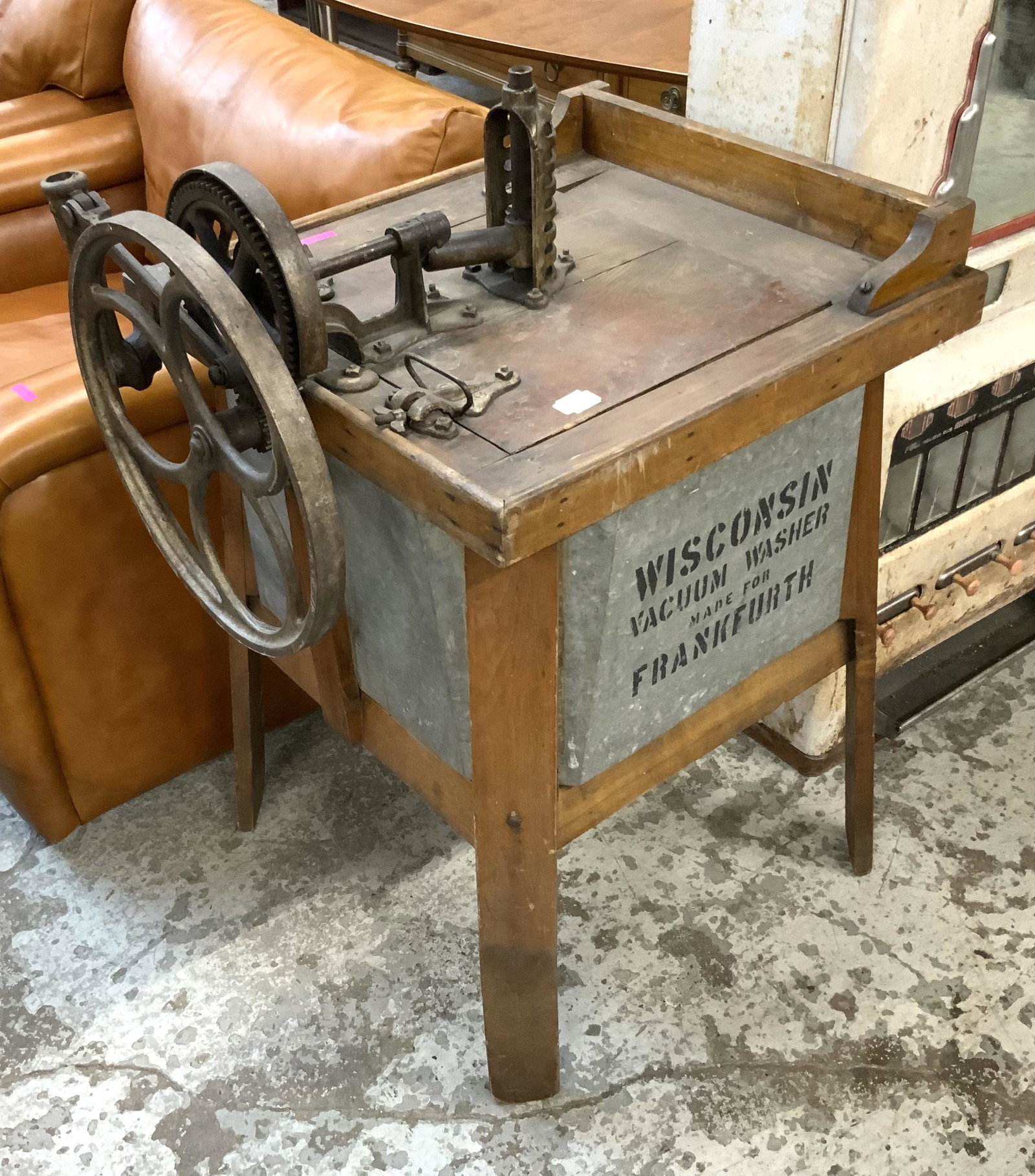 Antique Frankfurth,Wisconsin Vacuum Washer Machine: This unique washing machine consists of a wooden frame, a tin agitator inside of a hand-made tin tub, and a gear drive assembly made to be belt-driven. The Gear assembly works smoothly, the tin tub is