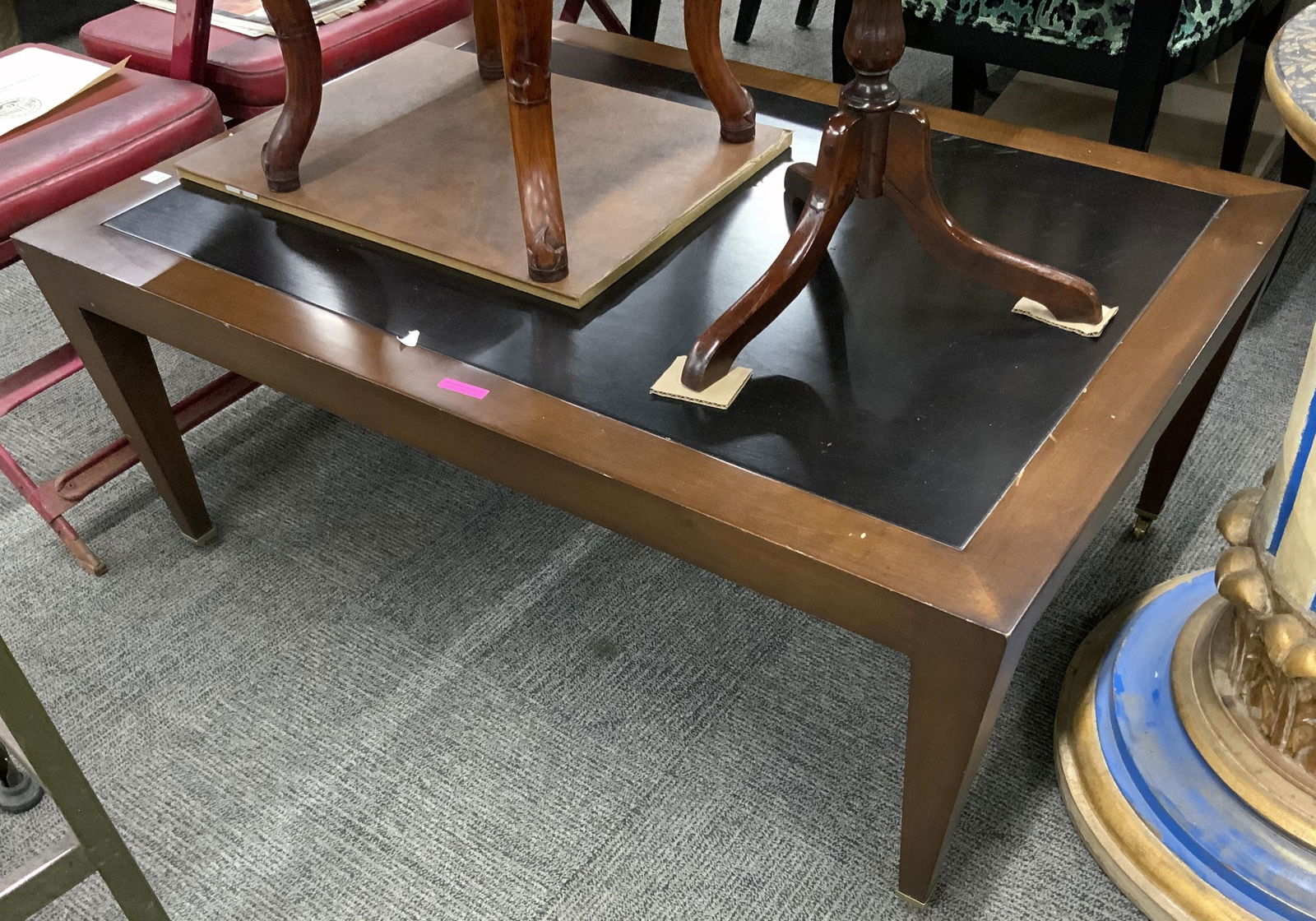 Two-Tone Wood Donghia Rectangular Coffee Table.: This table has Medium wood tones on the legs and frame of the table, with a black wood center area. The table shows signs of use, but is in good Useable Condition. It measures 42" wide, 30" deep, and