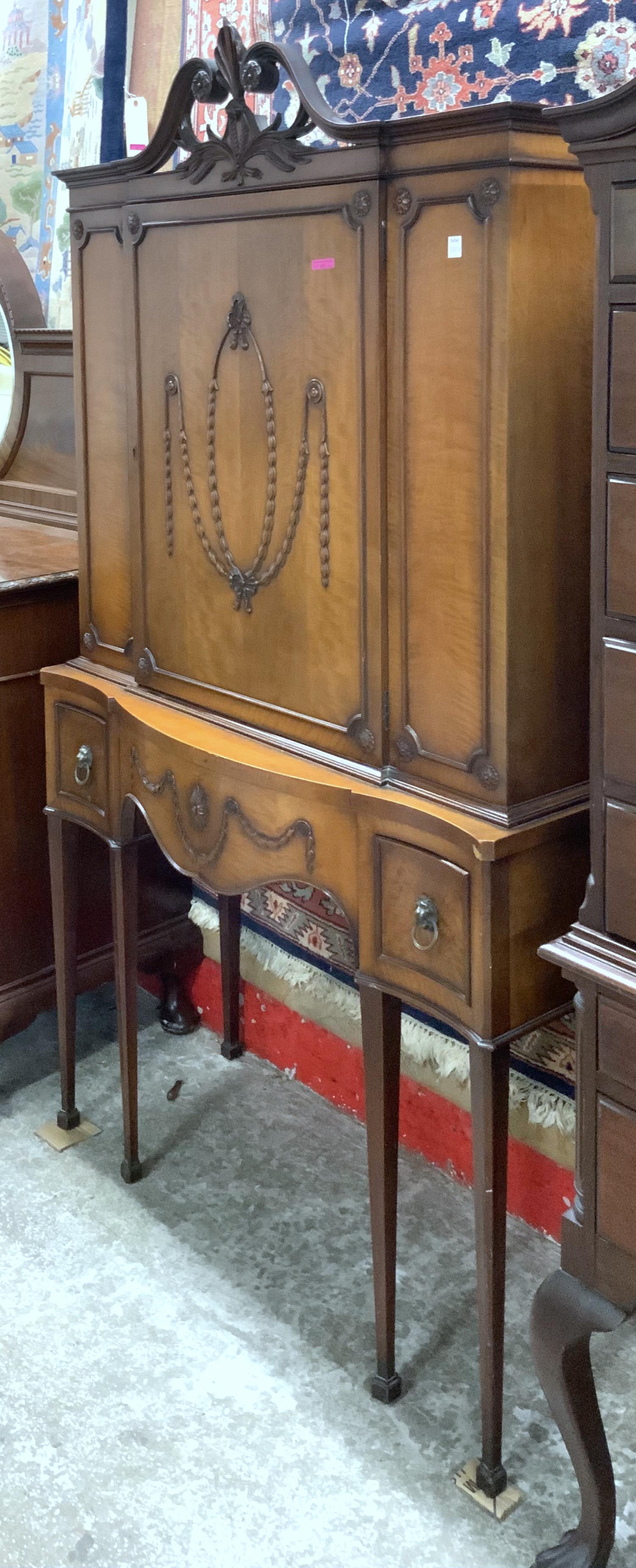 Walnut Closed-Door Sheraton-Style China Cabinet.: This cabinet has wooden designs on the large door and the drawer, and has Lions head drawer pulls. This cabinet appears to be in Good Overall Condition, but there is a small veneer chip on the right s
