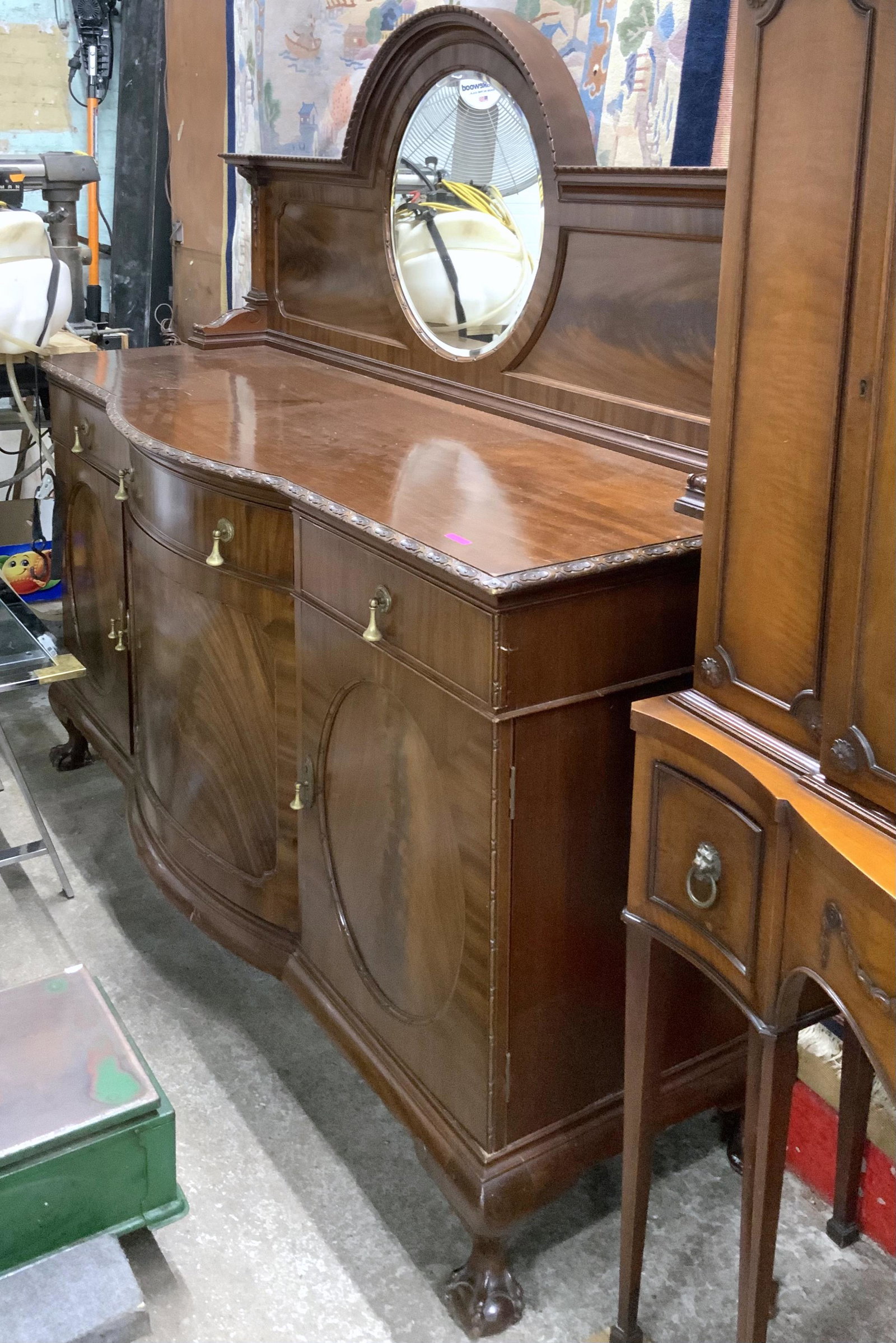 Large Antique Walnut Buffet Sideboard with Mirror.: The sideboard has a bowed front, 2 side doors with a circular design, a carved top edge with a great backboard (nicely trimmed), and a large circular beveled mirror. This piece also has large carved c