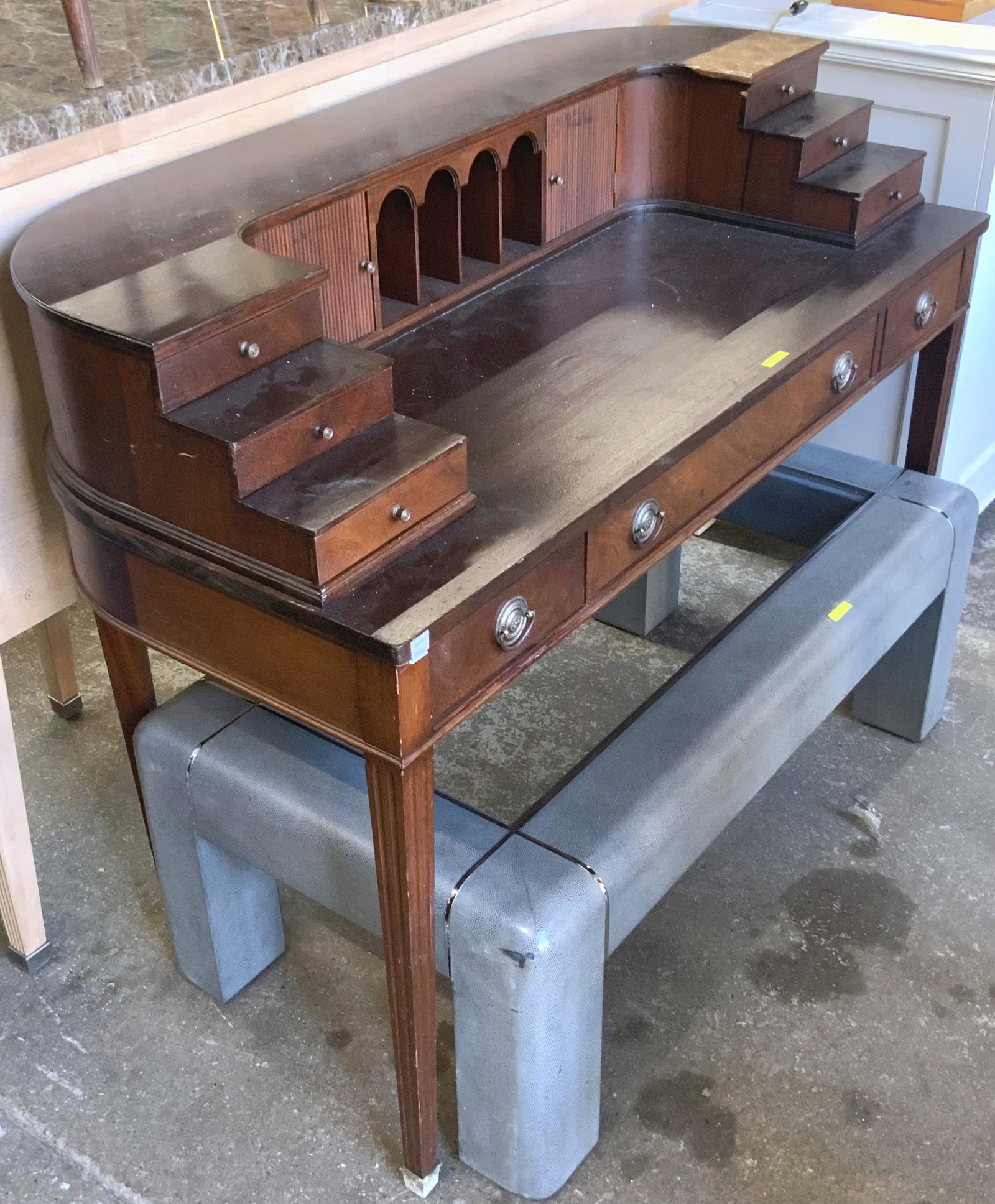 Curved-Shape Dark Wood Desk.: With Several Small Drawers and Cubbyholes. The Piece is in Fair to Good Condition, and measures 38 1/4" High, 50" Wide, and 24 1/2" Deep. Third-Party Freight Shipping or Personal Pickup Required.