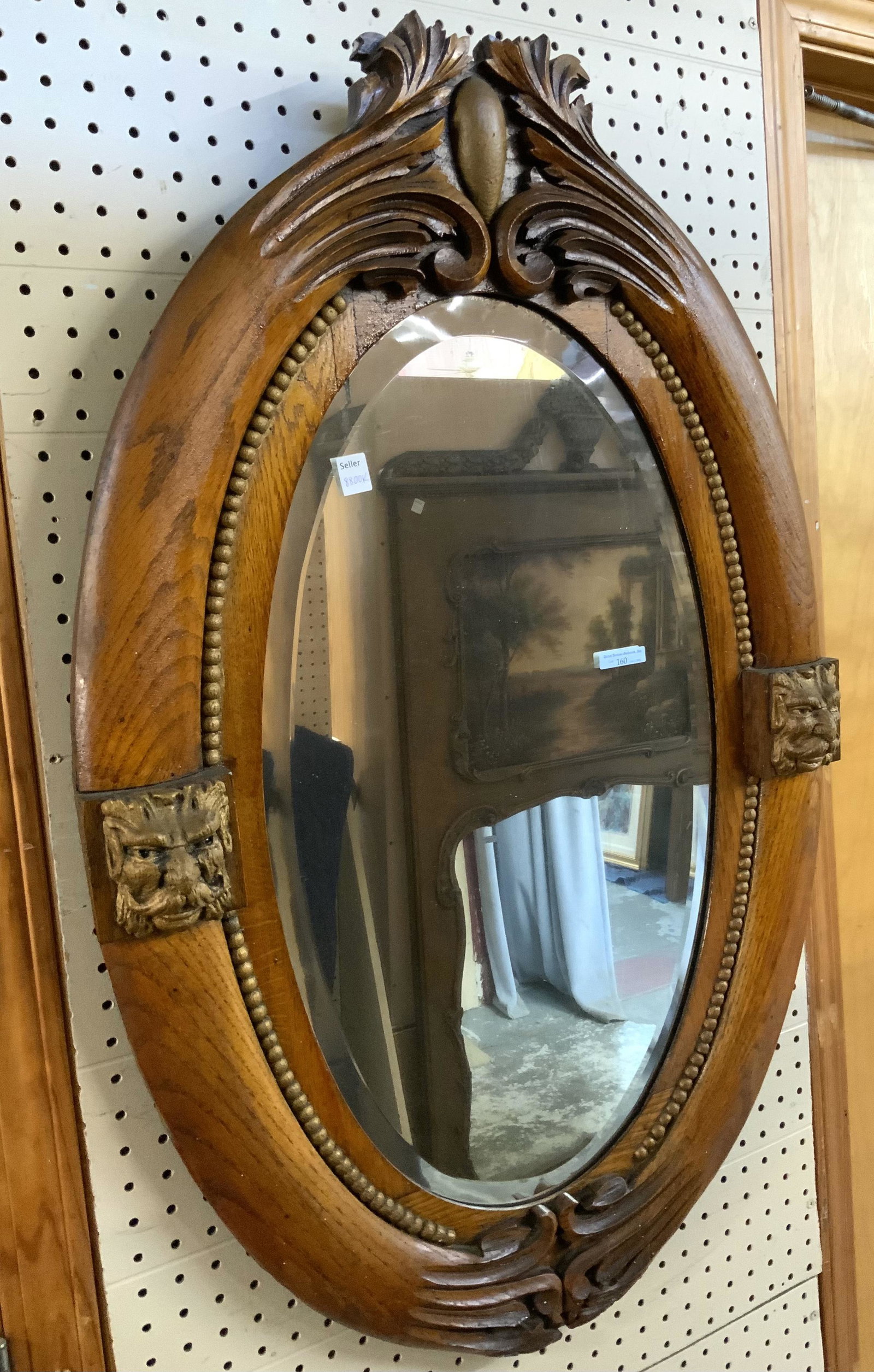Antique Oak Oval Mirror with Carved Faces.: The Bevelled Mirror is in Good Overall Condition, and measures 38 3/4" x 24 1/2". Third-Party Shipping or Personal Pickup Required.